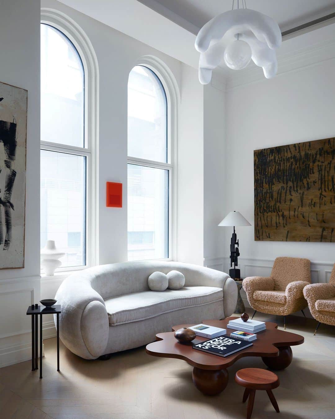 ELLE DECORのインスタグラム：「Well hello, you sexy thing. This curvaceous white sofa is the showstopper of this Manhattan apartment. Little surprise, then, that it was custom created for fashionista Christian Siriano (@csiriano) who knows a thing or two about what makes a beautiful silhouette. The sofa is an homage to 20th-century French designer Jean Royère, custom created for Siriano by Connecticut-based @kostas_upholstery. Siriano’s network of makers, vintage dealers, and artists extends across the tristate area and beyond, but he seems particularly loyal to Connecticut.   Click the link in the bio to tour the rest of this airy apartment, as featured in our November 2023 issue. Written by @julie_coe. Photographed by @timlenzphoto.」