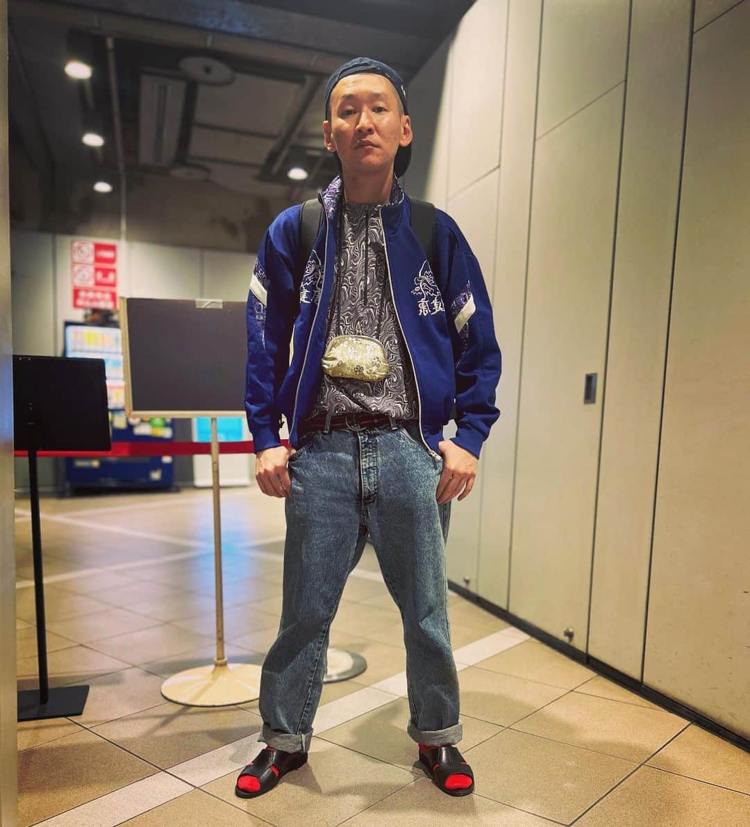 のインスタグラム：「今日の服装。 渋谷でライブの日。  難しい気温の中で十四才で購入したサイクリングシャツに健康のジャージ。 BOBSONのデニム。 JAのデニム地の帽子に黒の便所サンダルで金のがま口とmont-bellのメッシュリュック。  渋谷でライブ終わりに劇場出た所で撮りました。 少しずつでも進んでいこう。 渋谷ありがとう。 #今日着た服 #ファッション #古着 #健康 #サイクリング」