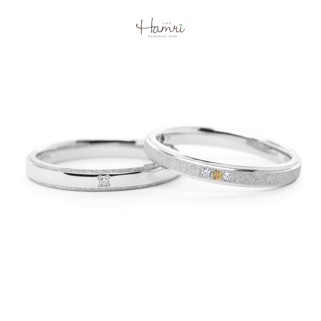 結婚指輪・婚約指輪『Hamri(ハムリ)』のインスタグラム：「【平打ちの指輪をご紹介です】  ご新郎様は鏡面仕上げの艶感をメインに縁のみスターダスト加工を施し、 シンプルなデザインにアクセントを加えました。 ご新婦様は反対にスターダスト加工のキラキラ感を主役にしていただき、 鏡面仕上げの縁が華やかさを際立てています。  また表面にお留めしたダイヤモンドもご新郎様は1石をシンプルに、 ご新婦様は3石のうち真ん中のみイエローダイヤモンドにしていただいたことで 女性らしい印象に仕上がりました♡  お二人ともベースは同じお素材、同じ形でお作りいただいておりますので しっかりとペア感はありつつも、お二人らしさを表現された素敵なデザインです！  内側にはお二人の記念日とイニシャルが刻印され、 間に誕生石留まったお互いの誕生石も、お色を悩みながらお選びいただきました！  お二人のこだわりが詰まった素敵な指輪が いつまでも輝き続けますように。 ご結婚おめでとうございます！  💓ふたりらしい指輪と想い出を💓 @hamri_omotesando ==========================  ♦︎♢作成中の写真や動画を撮影、全データプレゼント♢♦︎  DMやLINEでのご相談お待ちしております♥ ⇒@hamri_omotesando  ❁・❁・❁・❁・❁・❁・❁・❁・❁・❁・❁  ＊セットリング5%OFF＊  @hamri_omotesando  Hamri「ハムリ」  〒150-0001 東京都渋谷区神宮前5-11-11 2F  tel 0120-121-175 hp https://hamri.jp/  open 11:00〜19:00 close 火/水　祝日営業  ❁・❁・❁・❁・❁・❁・❁・❁・❁・❁・❁  #手作り結婚指輪 #手作り婚約指輪 #結婚指輪#マリッジリング #エンゲージリング #プレ花嫁 #Hamri #Hamri表参道 #オーダーメイドリング #鋳造 #ブライダルリング #ペアリング #鎚目リング #プラチナリング #ピンクゴールド #シャンパンゴールド #ゴールドリング #コンビネーションリング #2023wedding #2023春婚 #2023夏婚 #プレ花嫁準備 #プレ花嫁と繋がりたい #結婚指輪探し #結婚指輪選び #結婚準備  《Hamri検索タグ》  #hamriデザイン #hamri指輪作り #hamri花嫁」