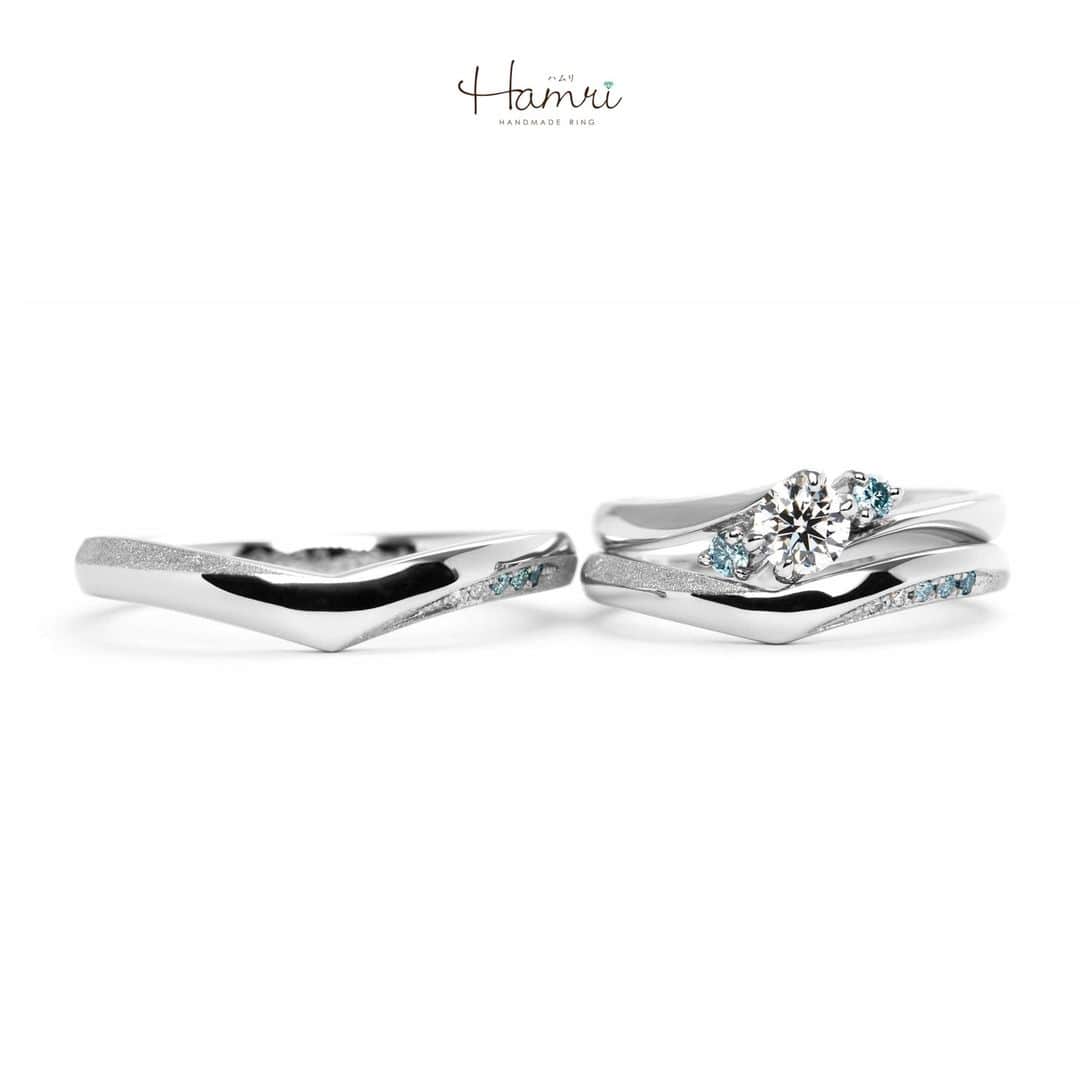 結婚指輪・婚約指輪『Hamri(ハムリ)』のインスタグラム：「【ブルーダイヤモンドの指輪をご紹介です】  婚約指輪はウェーブの形をベースにお作りいただきました。 美しい煌めきのH&C(ハート&キューピッド)ダイヤモンドに サイドのアイスブルーダイヤモンドが華を添えてくれるような、 女性らしく品のあるデザインが素敵です♡ 内側にはお二人のイニシャルと、記念日の誕生石が留まっております。  結婚指輪は、お二人お揃いのV字シルエットにひねりを加えたデザインです。 ひねりの窪みの部分にはスターダスト加工を施し、 ブルーのグラデーションが美しいダイヤモンドを5石お留めしております！ 婚約指輪と重ねていただいた際にも それぞれのブルーのお色味がしっかりと見えるデザインでお作りいただきました。  内側にはお二人の記念日、お名前の刻印と ご自身の誕生石もお留めして、 お二人だけの素敵な指輪が完成いたしました！ ご結婚おめでとうございます！  💓ふたりらしい指輪と想い出を💓 @hamri_omotesando ==========================  ♦︎♢作成中の写真や動画を撮影、全データプレゼント♢♦︎  DMやLINEでのご相談お待ちしております♥ ⇒@hamri_omotesando  ❁・❁・❁・❁・❁・❁・❁・❁・❁・❁・❁  ＊セットリング5%OFF＊  @hamri_omotesando  Hamri「ハムリ」  〒150-0001 東京都渋谷区神宮前5-11-11 2F  tel 0120-121-175 hp https://hamri.jp/  open 11:00〜19:00 close 火/水　祝日営業  ❁・❁・❁・❁・❁・❁・❁・❁・❁・❁・❁  #手作り結婚指輪 #手作り婚約指輪 #結婚指輪#マリッジリング #エンゲージリング #プレ花嫁 #Hamri #Hamri表参道 #オーダーメイドリング #鋳造 #ブライダルリング #ペアリング #鎚目リング #プラチナリング #ピンクゴールド #シャンパンゴールド #ゴールドリング #コンビネーションリング #2023wedding #2023春婚 #2023夏婚 #プレ花嫁準備 #プレ花嫁と繋がりたい #結婚指輪探し #結婚指輪選び #結婚準備  《Hamri検索タグ》  #hamriデザイン #hamri指輪作り #hamri花嫁」