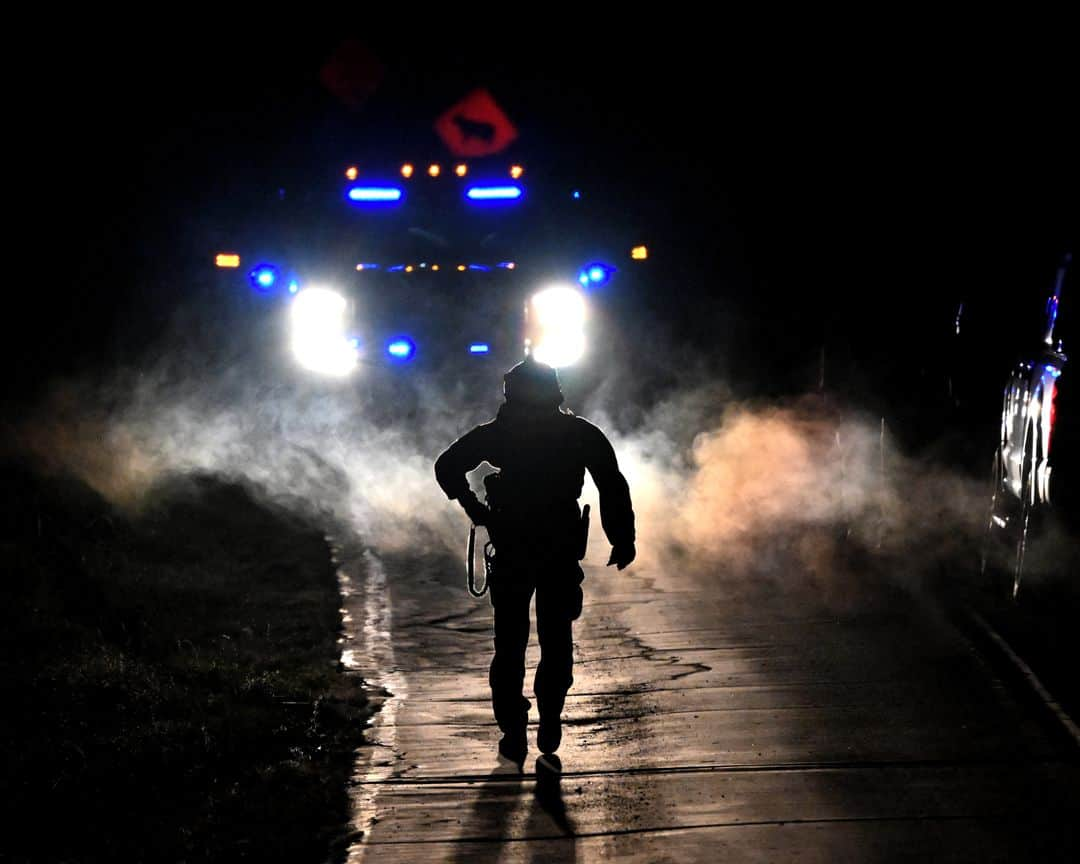 AFP通信のインスタグラム：「AFP Photo 📷 @angelaweissphoto - Law enforcement are seen outside the home of suspect Robert Card's father and brother in Bowdoin, Maine on October 26, 2023, in the aftermath of a mass shootings in Lewiston, Maine. ⁣ ⁣ Hundreds of police in the US state of Maine hunted October 26, 2023 for a fugitive gunman who killed 18 people at a bowling alley and a bar, as President Joe Biden mourned "yet another senseless and tragic mass shooting." Police named the suspect as 40-year-old Robert Card -- seen in surveillance footage pointing a semi-automatic rifle as he walked into the Sparetime Recreation bowling alley.」