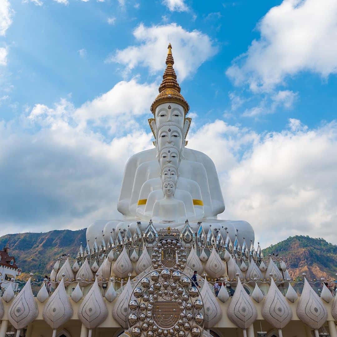 タイ国政府観光庁のインスタグラム：「. ༉‧₊˚ 🇹🇭わざわざ行きタイ旅！ ⠀ ⋯⋯⋯⋯⋯⋯⋯⋯⋯⋯⋯⋯✈  毎週土曜日は、まだあまり知られていないタイの観光スポットをご紹介♪   青い空に映える！「ワット・プラタート・パーソーンケーオ」へ✨  仏像が綺麗に並んだ姿が印象深いこちらの寺院🙏 トラベルカルチャー誌『TRANSIT』の表紙で見た❗️という方も、多いのではないでしょうか？👀   “タイのスイス”と称される、自然豊かなペッチャブーンは、「タイ12の秘宝」と呼ばれる隠れた名所として選ばれた地方都市のひとつ。そして、県内でも人気を誇るのが、このワット・プラタート・パーソーンケーオです💁‍♀️  瞑想に訪れる人々のため、アムナート・オーパーソー師によって建てられたこの寺院は、高い山々に囲まれた場所にあります⛰ 特に11〜4月のベストシーズンは、晴れ間が多いことから、１年のなかでも見事な景観が楽しめる時期です☺️  巨大な仏塔の壁や廊下の装飾は、宝石や、粉々に砕いた貴重な陶器が使われていて、煌びやか✨   ペッチャブーン市街からは、車で約1時間でアクセスできます🚗 静謐な空気のなか佇む美しい寺院へ、ぜひ参拝に行きましょう👏  ☆「行ってみたい！」：いいね❤をタップ ★「参考になった！」：保存ボタン🔖をタップ  #タイ #ペッチャブーン #ワットプラタートパーソーンケーオ #タイ寺院 #お寺巡り #仏像 #仏塔 #タイのスイス #秘境 #今こそタイへ #こんなタイ知らなかった #もっと知りタイ #はじめてのタイ #タイ旅行 #ペッチャブーン旅行 #旅好きな人と繋がりたい #thailand #phetchabun #phetchabuntrip #watprathatphasornkaew #temple #buddhastatue #pagoda #thainess #amazingthailand #thailandtravel #thailandtrip #thaistagram #lovethailand #amazingnewchapters」