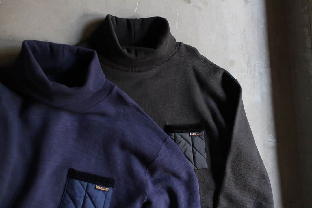 のインスタグラム：「▽ FW23 GG SWEAT HIGHNECK JM7366LV 100%COTTON POCKET:LAVENSTAR 100%POLYESTER ￥20,900 Color: 06 Harbour Blue 60 Lamp Black  50年を超える歴史がある 英国の老舗ファクトリーブランド 「Lavenham」とのコラボレーション  1900年代初頭の Baseballユニフォームの 補強パーツとして使われていた ストライプとスラントで形成した Jackmanオリジナルキルトパターンを ポケットのパーツとして配置した GGハイネックです  1920年頃の Baseballの風景に見られた 試合前の防寒セーターをイメージ  ゆったりした設計で 1枚で着用しても 雰囲気があります  今年の秋の新しいカタチ ぜひ」