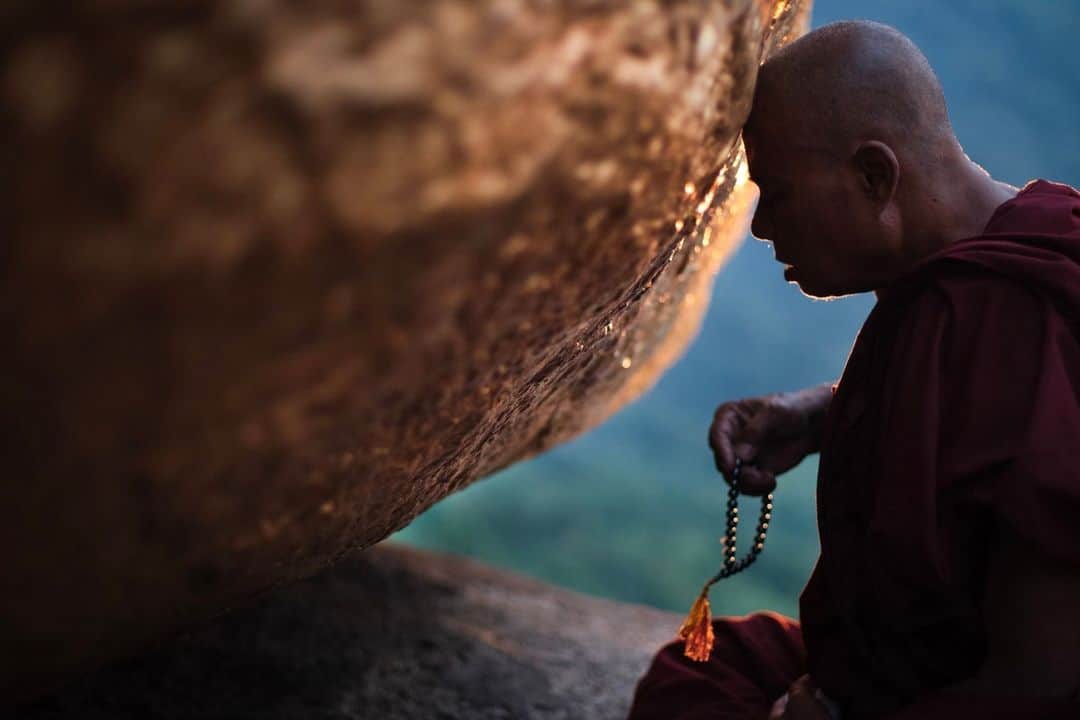 ナショナルジオグラフィックのインスタグラム：「Photo by @rubensalgadoescudero | A monk prays at Kyaiktiyo Pagoda, also known as Golden Rock, the third most important Buddhist pilgrimage site in Myanmar. Standing at the top of Mount Kyaiktiyo, Golden Rock is a small temple built on a granite boulder. The boulder is covered with gold leaves, which devotees paste onto the surface before praying.   I was supposed to go to Myanmar for one month in 2013. When I arrived, I immediately became enamored with the country and its people. I ended up staying for two and a half years. It is where I began my journey as a professional photographer.  Follow me @rubensalgadoescudero to see the world through my lens.」
