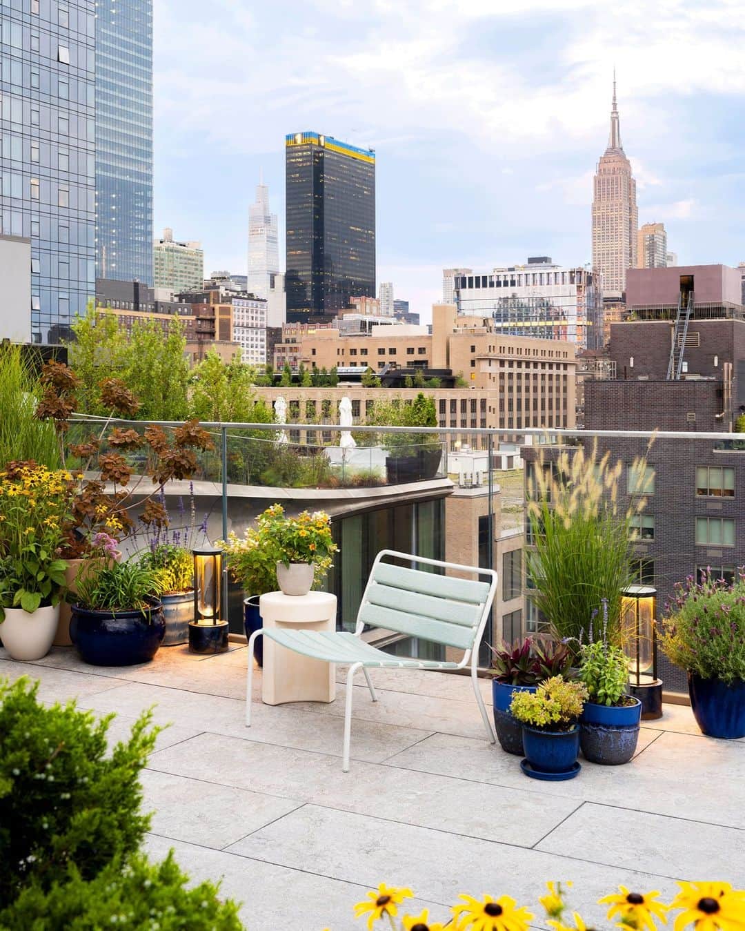 ELLE DECORのインスタグラム：「It’s difficult to say which view is better—the soaring New York City skyline or the stylishly furnished rooftop terrace you might be standing on. Whatever side you might lean on in that debate, one thing’s for certain: David Rockwell’s (@rockwellgroup) rooftop terrace overlooking Manhattan’s West Chelsea neighborhood is contendably the best rooftop in the city. Located atop a Zaha Hadid–designed building, this urban oasis is outfitted with furnishings awash in Rockwell’s favorite color, blue, which appears in various hues and forms from tabletops to planters.   Click the link in the bio to tour the rest of this rooftop refuge. Written by @stephen_treffinger. Photographed by @nicholascalcott.」