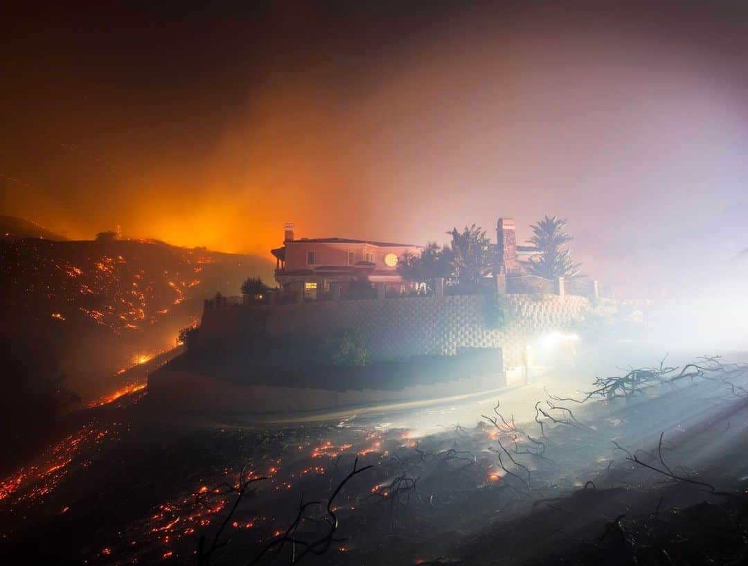 ナショナルジオグラフィックのインスタグラム：「Photo by @stuartpalley | The 2017 Canyon fire burns around a home in Corona, California. With the arrival of fall, Southern California enters the peak time for its Santa Ana winds. The winds originate from high pressure over the Great Basin, a desert area encompassing six states. As wind is pulled toward the coast over and through the mountains, it leads to drier air and warms it through compressional heating. The end result: winds that can cause destructive wildfires. However, a wet winter, rainy summer, and likely upcoming El Niño pattern collectively could mute fire activity, leading to a reprieve for a state with record-setting wildfires in recent years.   This week the state is seeing a fall heatwave, leading to temperatures 15-degrees above normal, a hopefully tranquil reminder of the destructive weather patterns than can wreak havoc with wildfires in the state.」