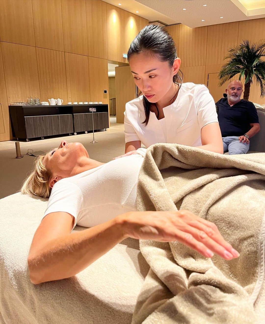 朝井麗華のインスタグラム：「南仏・ニースでの公開施術デモンストレーション 【※閲覧注意】 今回は特に不思議に見えるかもしれません。  事前情報〉 この被験者さんはストレスが酷く、超ベビースモーカー。毎日ひどく悩み、たくさんの煙草を吸っていたそうです。  事前読み解き〉 セッション前に私は彼女の「左眼（〜視神経）」と「左右の肺」に過去のトラウマと細胞の傷付きを感知しました。そして、それらは今まさに、出たがっていることも。  セッション〉 まず左眼、右肺に溜まっていたエネルギーリリースを行い、そして左肺。ここには右肺よりもとても深く刻まれた古いネガティヴエネルギーが溜まっていて、それらのリリースを。  反応①〉 彼女は「両手が浮いていく感じがする」と言い（画像①）、 徐々に上がっていった両手は画像のとおりのポーズに（動画③）。 その後彼女は、「この手のまま動かせない！」とのこと。 両肺のネガティヴエネルギーを解放するために一番最適な誘導ルートは彼女の無意識と細胞がちゃんと知っていて、この様に自然に導いてくれました。🫁のエネルギーリリースにこのポージングがもっとも適していたんでしょう。  反応②〉 さらに、足先から震え出したので（動画②）、動きに制限をかけない様上にかけていたブランケットを外すとその震えは全身へ（動画③④）。 映像のとおり、彼女は全身の細胞を盛大に震わせ、自らの内に永年閉じ込めていたトラウマ・ネガティヴエネルギーをリリースしました。  カンファレンスという時間の限られた公開施術。閉館時間になってしまったがこの状態で中断したくなかったので少し延長させてもらい、約45分間これは続いた。  観覧者の声〉 この光景に会場の誰もが「元に戻らないんじゃないだろうか！？（この手の形や体の震えは止まらないんじゃ！？）」と心配に感じたと。目の前で繰り広げられるこの信じ難い光景を、ただひたすら見守る以外なかったと。中には、「とても興味深いセラピーだけど、自分がこれを受けるのは怖い」と感じる方も。  しかし、こうもエネルギーの動きを目の当たりにすると、「見えないものも確かに『ある』と認める他ない」とは誰もが納得せざるを得なかったこと。  私の思い〉 私が伝わったらいいな、と思うのは、昔々のストレスやトラウマがいつまでも尾を引いて未来のあなたに影響し続けているということ。これほどのエネルギーを身体に溜め込んだまま実は生活しているということ。日頃検知できない様、忘れ去らせてくれている健気な身体。身体は本当にあなたを生かすためにがんばってくれているってこと！だから、もっと自分の身体と仲良くして欲しい。他人や世間、情報ばかりに目を向けず、内へ内へと意識を向けて欲しい。そうすれば、私でなくとも、誰もが自分で内の細胞と会話できる…！！  被験者の声〉 さてセッション後、彼女は 「セッション中、いろいろなことが起こったので、終わってみれば、夢だったのか現実だったのか、不思議に思うほどだった。 そしてそれは現実だった！麗華の手にかかると、自分の体をコントロールできなくなるのは壮絶だ。」 その他にもたくさんのことをお話くださったので、フランス語がわかる人は動画⑦を見て欲しい。  さらに翌日嬉しい報告が！ 「あれほどあったストレスがすっかり心から無くなり、とても穏やかで、そして昨日からタバコを一本も吸ってない！」と。（画像⑧）  この公開セッションは9/5に行ったが、なんとその日以降いまだに彼女はタバコを吸っていないんだそう（10月5日現在：1ヶ月！）外食に出かけ、目の前で友人がタバコを吸っていても吸いたい衝動にさえかられないんだそう。このセッション前までは一日中吸っているほどのスーパーベビースモーカーだったのに！  見解〉 彼女は私にタバコを辞めたいと言ったわけでもないし、タバコを辞められるためにセッションモデルを引き受けたんではない。  しかし結果的にタバコから遠のいたのは、 彼女にとってのタバコは、肺に溜め込んだ深い「悲しみ」「傷心」を麻痺させるため。タバコなしではダイレクトにそれらが自分を辛くさせ続けるため、タバコの毒でそのネガティヴエネルギーの感度を紛らわせていたことを私は感じた。  今回肺に溜まっていた悲しみのトラウマリリースを行ったことで細胞の傷が癒え、麻痺させたかったものが薄まり（ゼロに出来たかどうかは分からないので「無くなった」とは書かない）、その副産物としてタバコは必要なくなったのです。  Special Thank you❤️〉 会場 @anantaraplazanicehotel スパマネージャーはじめホテル関係者の皆様 観覧にお越しくださった方々 セッションモデルを引き受けてくださった被験者さん 通訳 @satoshi_yaku  エージェント @fjacquemin30  #Reikamethod #traumarelease #traumatherapy #bodymindspirit #subconsciousmind #Tuina  #lifetherapy #Lifetherapist #Orientalmedicine #France #Japan #トラウマリリース #トラウマ #トラウマセラピー #ライフセラピー」