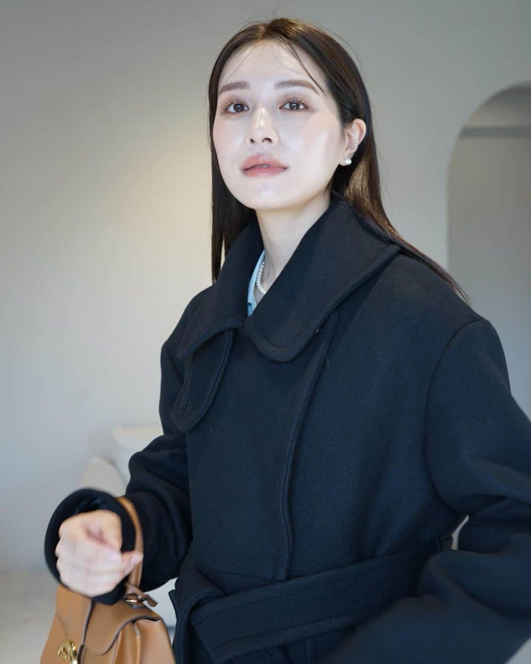 のインスタグラム：「Double-breasted Wool coat / Black  高品質ウール100%の生地を使用したダブルブレストコート。大きな襟のふちに太めのステッチをかけてアクセントにしました。  襟部分にはスロートタブが付いているので、写真のように3段階の襟元の変化を楽しめます☺️  明日10/7(土)20:00より発売です✨」