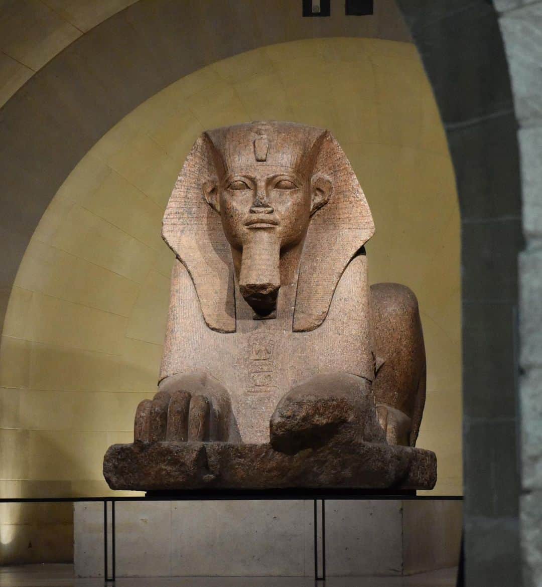 のインスタグラム：「. 🇫🇷 Inspectons les œuvres du musée avec #LouvreALaLoupe ! Aujourd’hui, intéressons-nous au grand sphinx de Tanis.   - 👀 C'est un des plus grands sphinx conservés hors d'Égypte. Il a été trouvé en 1825, parmi les ruines du temple d'Amon-Rê, à Tanis, capitale des 21e et 22e dynasties.   - ✍️ En granit rose, il apparaît le corps tendu et les griffes sorties, prêt à bondir. Sous chacune de ses pattes est sculpté, sur le socle, un signe hiéroglyphique « chen » qui peut évoquer un cartouche, confirmant le caractère royal du monument.  - 🦁 Le mot grec « sphinx » est utilisé de façon courante pour désigner les statues égyptiennes représentant un lion à tête humaine, mais il ne correspond pas à la réalité. Chesep-ankh, c'est-à-dire « image vivante », était la formule adéquate pour désigner, en égyptien, une statue ou une image de cette nature. C'est une représentation symbolique de la relation étroite entre le dieu solaire (corps de lion) et le roi (tête humaine).    ∴ 🌎 Let's inspect the museum's works with #LouvreALaLoupe! Today, let's take a look at the Great Sphinx of Tanis. - 👀 This is one of the largest sphinxes preserved outside Egypt. It was found in 1825, among the ruins of the temple of Amon-Ra, in Tanis, capital of the 21st and 22nd dynasties.   - ✍️ Made of pink granite, its body is taut and its claws are out, ready to pounce. Under each of its legs, a hieroglyphic sign "chen" is carved on the base, evoking a cartouche and confirming the monument's royal character.  - 🦁 The Greek word "sphinx" is commonly used to designate Egyptian statues depicting a lion with a human head, but it does not correspond to reality. Chesep-ankh, meaning "living image", was the appropriate Egyptian term for a statue or image of this kind. It is a symbolic representation of the close relationship between the solar god (lion body) and the king (human head).  - 📷 © Musée du Louvre / Nicolas Bousser  . . . #Louvre #MuséeDuLouvre」