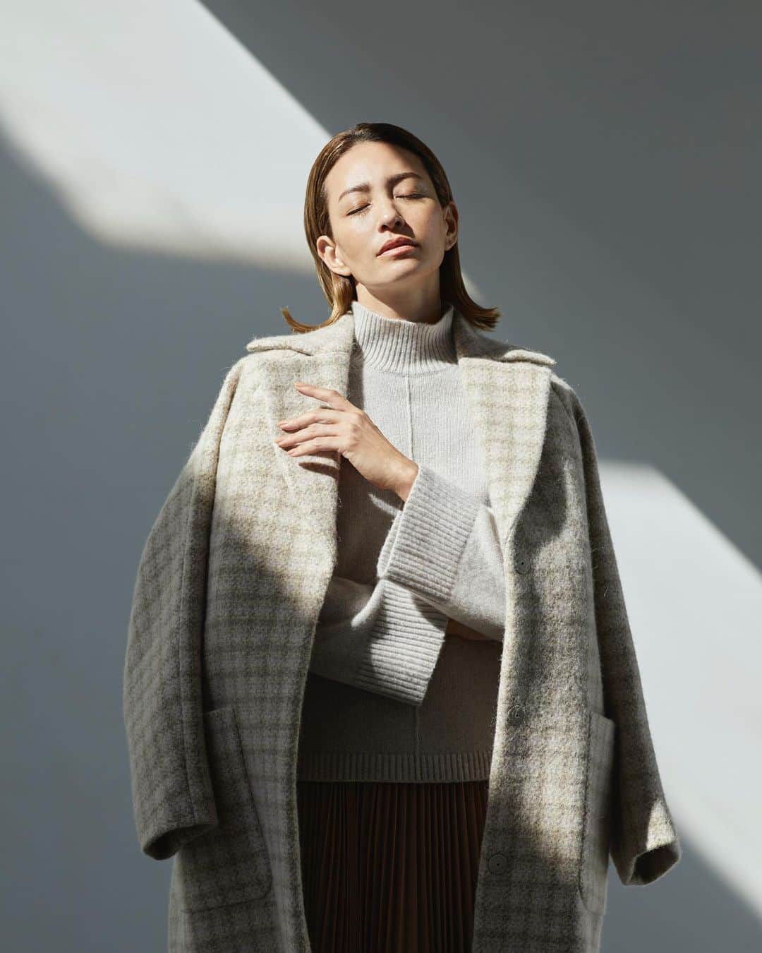 Theory luxe official account.のインスタグラム：「［FALL 2023 COLLECTION -October-］  ブランドオリジナルのニュアンスベージュのチェック柄を、イタリアの高級生地メーカーに別注したロングコート。 前身頃はドロップショルダー、後ろ身頃はドルマンスリーブで変則的な丸みを出したオーバーサイズシルエットがモダンな印象をもたらします。  「上質なウールにアルパカのソフトな風合いを足したテクスチャーは、一見して上質と伝わるクオリティ。トーン・オン・トーンのチェック柄コートから始めるブラウニッシュな着こなしで秋を感じさせて」（リタさん）  #theoryluxe #セオリーリュクス #チェックコート #プリーツスカート #ワントーンコーデ」