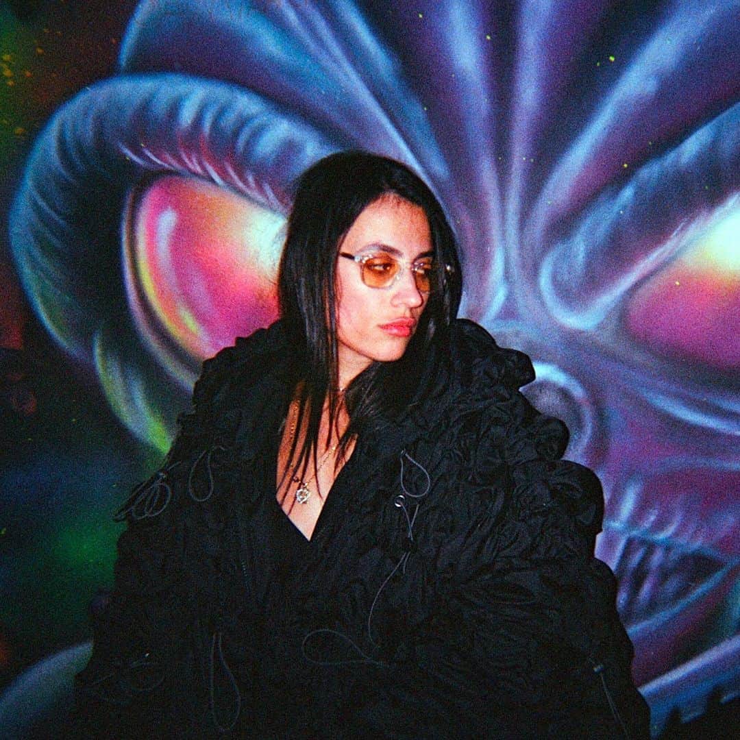 Dazed Magazineさんのインスタグラム写真 - (Dazed MagazineInstagram)「@COUCOUCHLOE arrives at @NQ64arcadebars in Shoreditch and almost immediately spills a drink over herself 👾⁠ ⁠ Although her ultra-gorpcore @anaselivanova jacket is collateral damage, she styles it out – her skin and hair glisten with a glass’s worth of booze and she adds a slick of lipgloss to finish the wet look. The bar we’re in is dark and neon-lit with flashing retro consoles and a very loud Chief Keef soundtrack.⁠ ⁠ The @nuxxe_ collective member has just released mixtape Fever Dream, a collection that is “two years of friends and life and everything”, she says. It draws together an impressive crop of collaborators including @eartheater 645ar @louisbrodinski @iamrealnene and mop-haired teen rapper @mattox⁠ ⁠ The cover art is a sketched caricature of COUCOU CHLOE, with an exaggeratedly large forehead, droopy-lidded eyes and a plumped-up, dissociative pout. “I liked the idea of a caricature, or a grotesque, as a way to let go... It was really interesting to see the perspective of someone who doesn’t know me at all. It's like, ‘What do you see?’”⁠ ⁠ Read the full interview through the link in our bio 🔗⁠ ⁠ ✍️ @felicitaaaay⁠ 📷 @hattirex⁠」10月7日 1時02分 - dazed