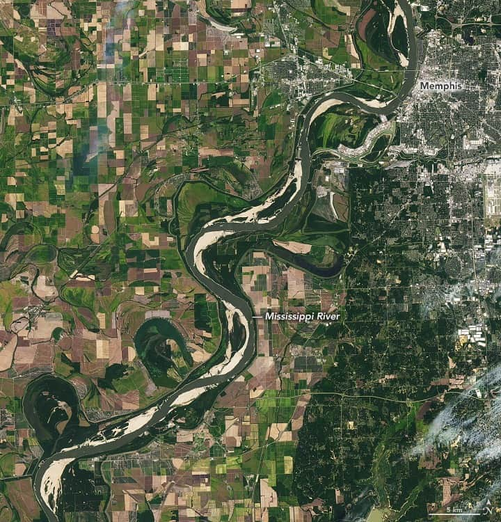 NASAのインスタグラム：「Drought and intense summer heat have caused the Mississippi River's water levels to drop to near-record lows in many areas, exposing the river bottom and disrupting the transport of goods.  Louisiana and Mississippi experienced their hottest Augusts on record, according to @NOAA, and many parts of the South continued to experience extreme drought in late September. Lack of freshwater flowing into the Gulf of Mexico has allowed salty ocean water to flow up the river in some areas of Louisiana, contaminating drinking water.  This NASA / @usgslandsat image from September 16 shows the Mississippi River near Memphis, Tennessee, where water levels fell so low that the sandy river bottom could be seen from space.  Image Description: An image from space of the Mississippi River near Memphis, Tennessee. The river looks like a wide gray-green ribbon curling diagonally through the center of the image from bottom left to upper right. Light sandy areas can be seen throughout the river, as low water levels allow the river bottom to show through. Gridded farmland in shades of brown and green surrounds the river on either side, with the right half of the image mostly covered by the darker green suburbs of Memphis. The city appears in the upper right, with gray and white urban areas and roads.」