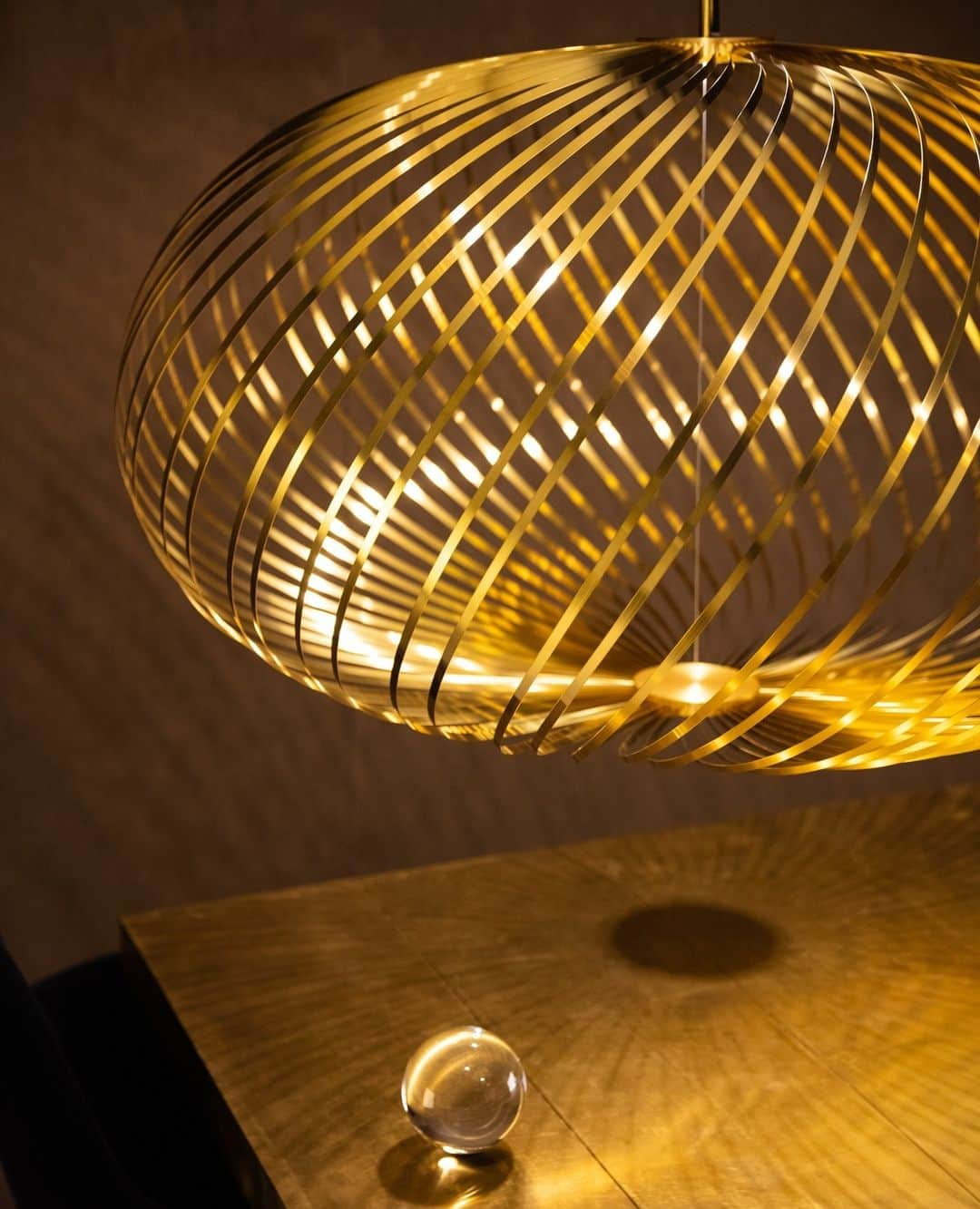 トム ディクソンのインスタグラム：「SPRING pendants are made from multiple bands of high-performance Spring Steel plated in a brass finish and arranged like a whisk around a custom-made dimmable LED disc.⁠ ⁠ The semi-transparent shape created can be adjusted to a variety of silhouettes - from a flat arrangement reminiscent of a spirograph drawing to a flying saucer configuration and on to a fuller shape akin to a pumpkin. ⁠ ⁠ Available now on tomdixon.net ⁠ ⁠」