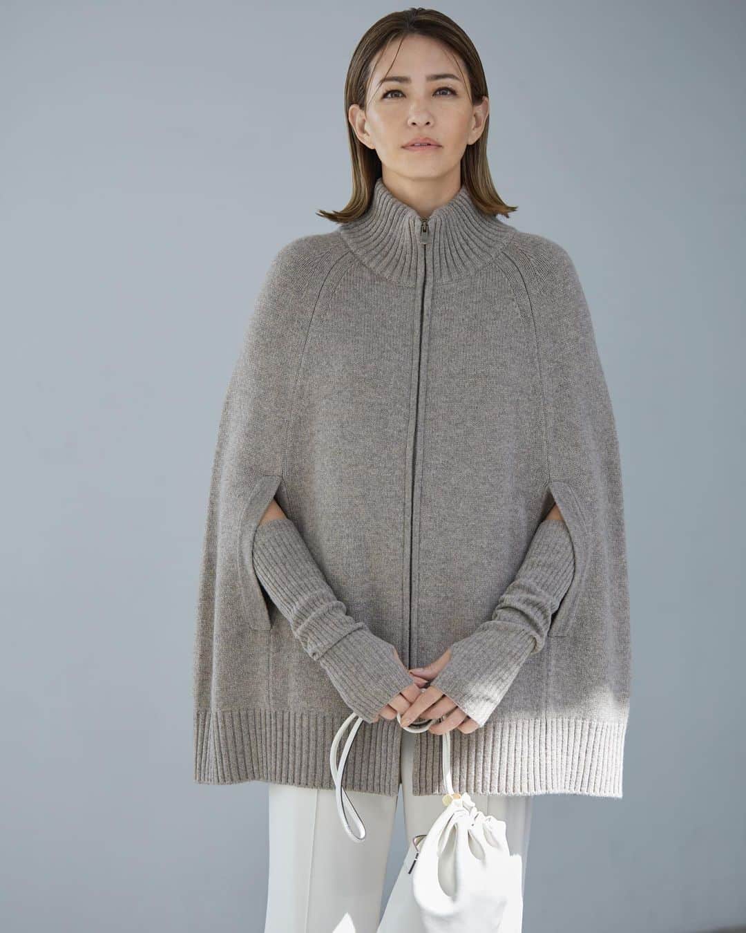 Theory luxe official account.のインスタグラム：「［FALL 2023 COLLECTION -October-］  極細ウールとカシミヤをブレンドして編み上げることで、エアリーなふくらみと軽やかさを実現したグレージュのケープ風カーディガン。 フロントのジップアップディテールとヒップをすっぽりと覆うレングスで、アウター感覚で着られる一着です。  「付属のリブ編みアームウォーマーをセットで身につけるとモード感アップ。ボトムにアイボリーなどくっきりとした色味を合わせると、スタイリッシュな雰囲気で着こなせます」（リタさん）  #theoryluxe #セオリーリュクス #ポンチョ #アームウォーマー #パンツスタイル」