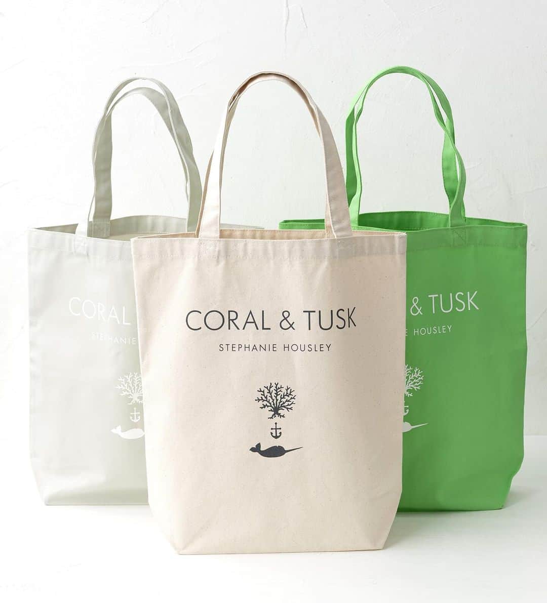 コーラル アンド タスクのインスタグラム：「お知らせです🎉 Coral & Tusk初の書籍発売を記念して、出版社「主婦の友社」が「CORAL＆TUSK」公認キャンバストートバッグを作りました👏   全3色、各2,420円 税込です。主婦の友社オンラインショップ「Shufutomo Shop」で販売中です。 プロフィールのリンクから、この投稿と同じ写真をクリックすると、主婦の友社オンラインショップの商品ページにつながります。  「CORAL＆TUSK」のロゴは、ステファニーの大好きなコーラル（珊瑚）と一角獣のタスク（牙）にちなんで形づくったもの。 一角獣の牙はナーウァル・タスクと呼ばれ、幸福のシンボルといわれています。  Coral & Tuskは刺繍がメインのブランドですが、こうやってロゴを使って素敵なトートを作っていただき、とても嬉しいです。書籍と一緒に大切な方にプレゼントするのにもぴったり🎁ぜひサイトをチェックしてくださいね。  「ナチュラル」「ライトグレー」「ライム」の3色で展開しています。まち幅が11cmあり、A４の書類やノートパソコンが入るちょうどいいサイズで、肩から掛けられるお出かけタイプなので、ふだん使いにおすすめです👍  ＊Coral & Tuskのウェブサイトでは販売しておりませんので、ご了承ください。」