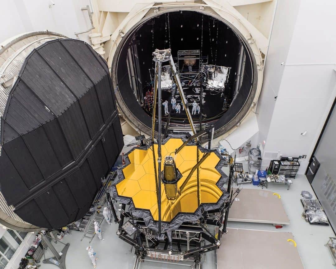 ナショナルジオグラフィックのインスタグラム：「Photos by Chris Gunn @thelightandthelens | I joined the James Webb Space Telescope team in 2009 as a scientific and technical photographer. I captured the integration of Webb’s instruments and iconic mirror segments at the NASA Goddard Space Flight Center, in Maryland. I then followed the assembled telescope to the Johnson Space Center, in Houston, and later witnessed its final integration to the spacecraft bus and sun shield at Northrop Grumman in Redondo Beach, California. The last leg of my Webb saga took me to the European Space Port in Kourou, French Guiana, where I documented the launch campaign.  In these images: Webb’s optical element after successfully completing a hundred-day cryogenic test inside NASA’s historic Chamber A, in preparation for the deep chill of space. I was suspended on a lift more than a hundred feet high.  Webb technicians and engineers work to close the massive doors on the telescope’s custom shipping container, called STTARS.  Webb’s secondary mirror is deployed and reflected in the primary mirror—the first and only powered deployment of this system. The lighting was achieved by illuminating the clean room wall reflected in the mirrors.  Before shipping to the launch site, the observatory was slowly tilted into a horizontal position, as engineers and technicians monitored the move.  Read the full story at the link in bio. #WorldSpaceWeek」