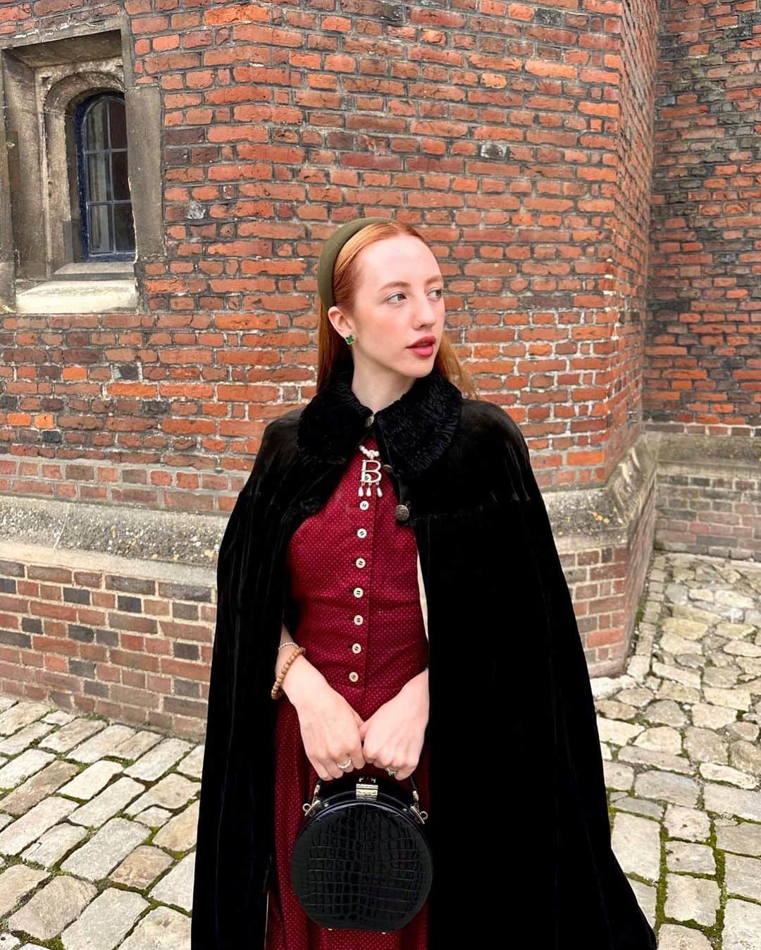 ベッキー・クルーエルのインスタグラム：「if you can’t wear a cape in hampton court palace i’m not sure where you can 🌹?  I have always wanted to see this incredible tudor palace for myself and I was so excited to have the chance!  they had live cooking demonstrations inside the original kitchens, and we saw so many amazing tapestries and paintings… incredible day to visit!  the puff headband trend always reminds me of the French Hood so I had to wear this army green one, along with this spectacular velvet and silk cape picked up from @classiccarbootsale in the spring! My dress is vintage from Japan, and my bag is @aspinaloflondon. The shoes are @empressaustralia 🔍  Not forgetting my B necklace as an homage to Anne 🅱️❤️」