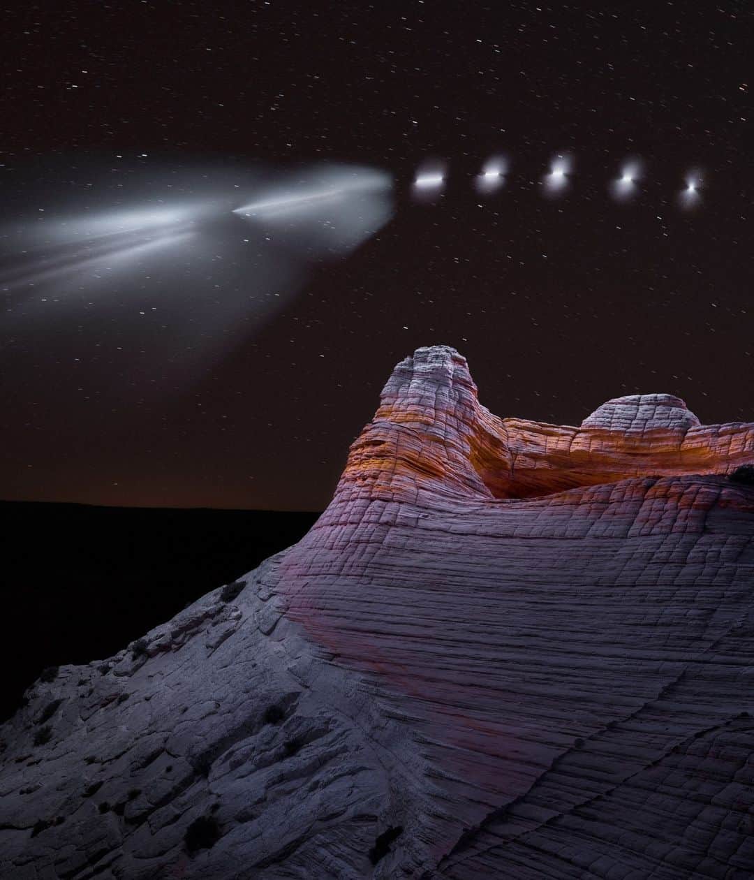ナショナルジオグラフィックのインスタグラム：「Composite image of 15 sequential photos by Reuben Wu @reuben | The SpaceX Falcon Heavy rocket leaves Earth's orbit on February 6, 2018. During a late-night photo shoot for a series in the wilderness of northern Arizona, I noticed a fast-moving point of light in the sky behind this rock formation. Without knowing what it was (and slightly concerned), I kept pressing the shutter button until it expanded into a glowing white cloud. It was at that moment I realized I was witnessing a rocket launch.  Later I received confirmation that it was indeed the first demonstration flight of the Falcon Heavy that launched from Florida but left Earth's orbit somewhere over Arizona—a very serendipitous photobomb. For more photos, follow me @reuben #WorldSpaceWeek」
