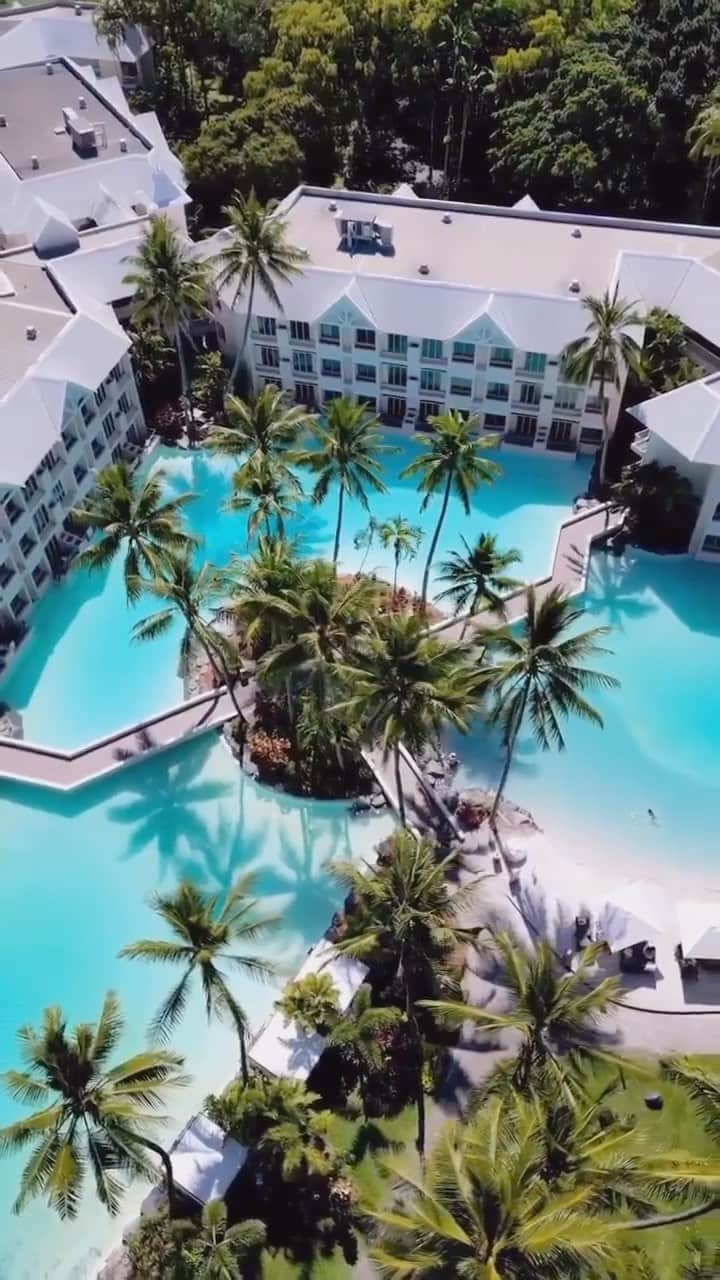 Australiaのインスタグラム：「Floating on cloud nine at @sheratongrandportdouglas 🌤️ This five-star beachfront hotel in @tropicalnorthqueensland makes a luxurious base for an incentive program, with 295 luxury guest rooms, five acres of saltwater lagoon pools, an array of bars and restaurants and ample event spaces onsite. Given its proximity to the @gbrmarinepark, the hotel takes #sustainability seriously and offers guests the opportunity to make a positive impact during their stay through @marriotbonvoy’s Good Travel program. Guests can undertake a cleanup of #FourMileBeach in partnership with @tangaroablue, then input their findings into the Australia Marine Debris Initiative database, which helps industry and government to create change on a larger scale 💙.   🎥: @abovequeensland   📍: @sheratongrandportdouglas, @tropicalnorthqueensland, @queensland - home to the Kuku Yalanji peoples.   #SeeAustralia #ComeAndSayGday #ThisIsQueensland #MeetInAus #ExploreTNQ  ID: An aerial view of a luxurious resort shows three wooden pathways converging at a central island adorned with palm trees. Accomodation sits right one the pool edge.」