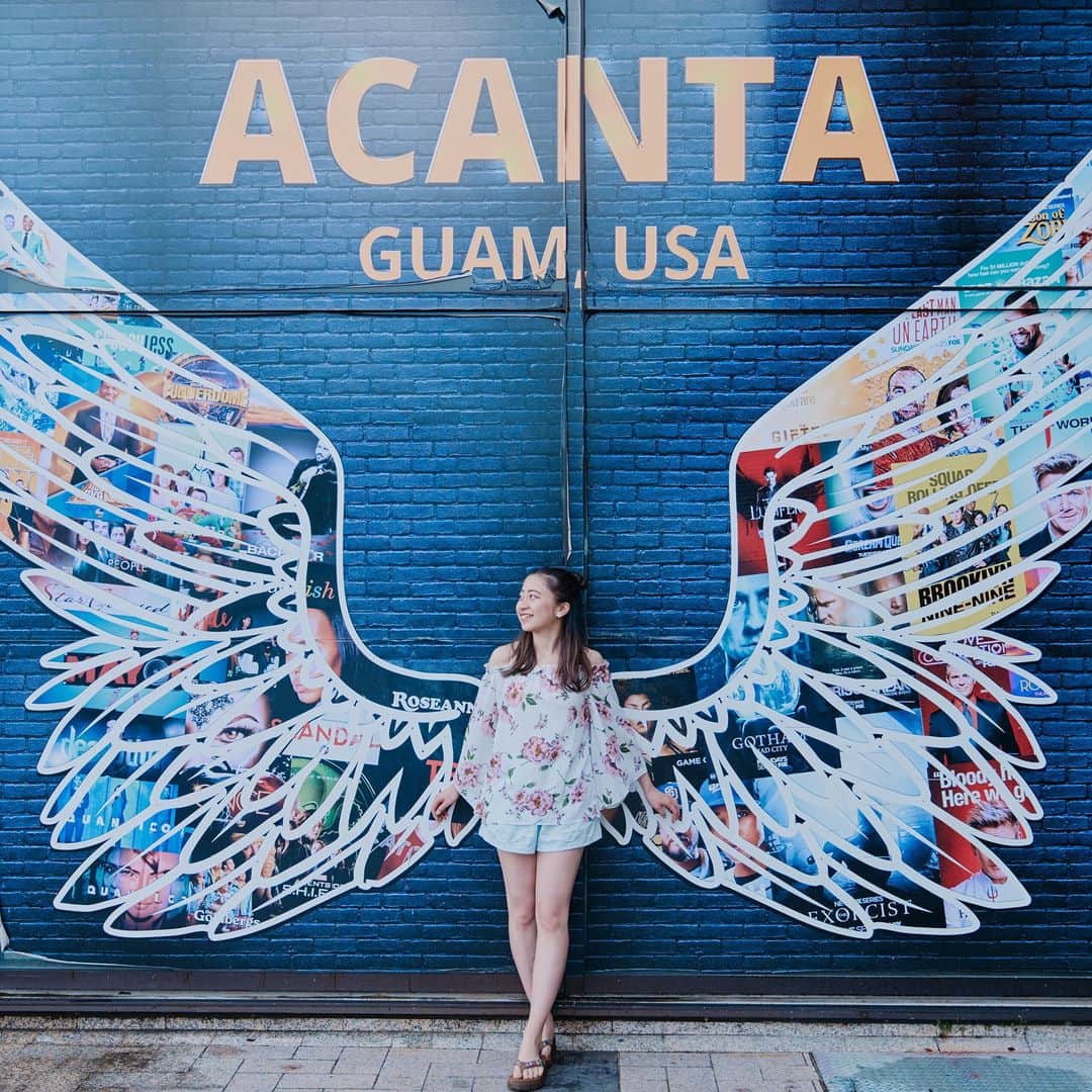 グアム政府観光局のインスタグラム：「インスタスポットとして有名な「アカンタモールの天使の羽」  背景が黒色の天使の羽って珍しいですよね。  モデルになった気持ちで、目線は斜め上を見るとカッコよく撮れますよ。  魅力的な写真を撮影してみてください。  #hereweguam #Guam #グアム #insta #weekend #instagood #instaphoto #旅行 #海外旅行 #instagram #アカンタモール #天使の羽 #アカンタモールの羽 #映えスポット #映え旅」