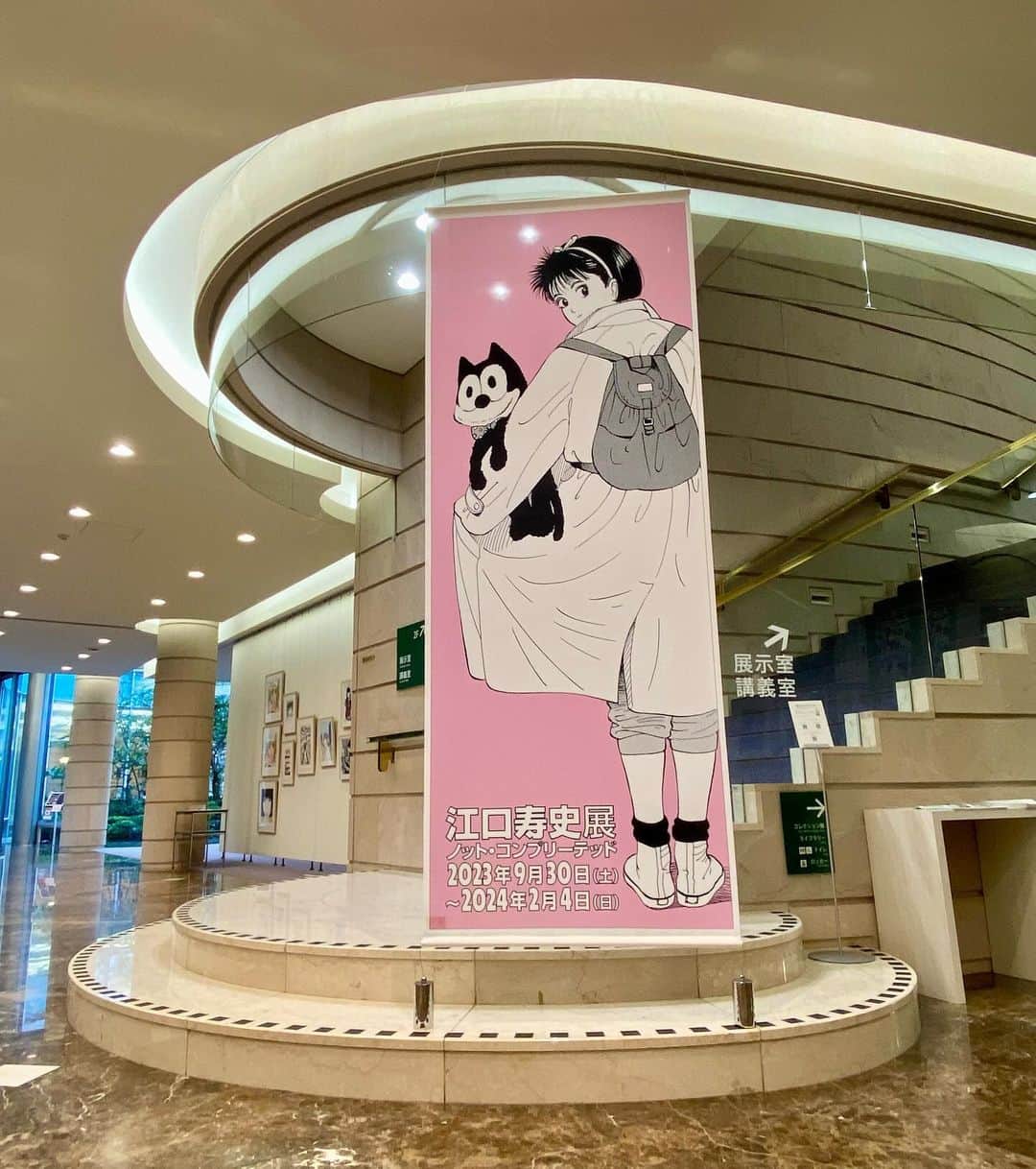 江口寿史のインスタグラム：「BGMの追加と展示に手を入れにきました。初日にはなかった(間に合わなかった)、会場に上がる階段横と、入り口受付前のバナーもついてました。」