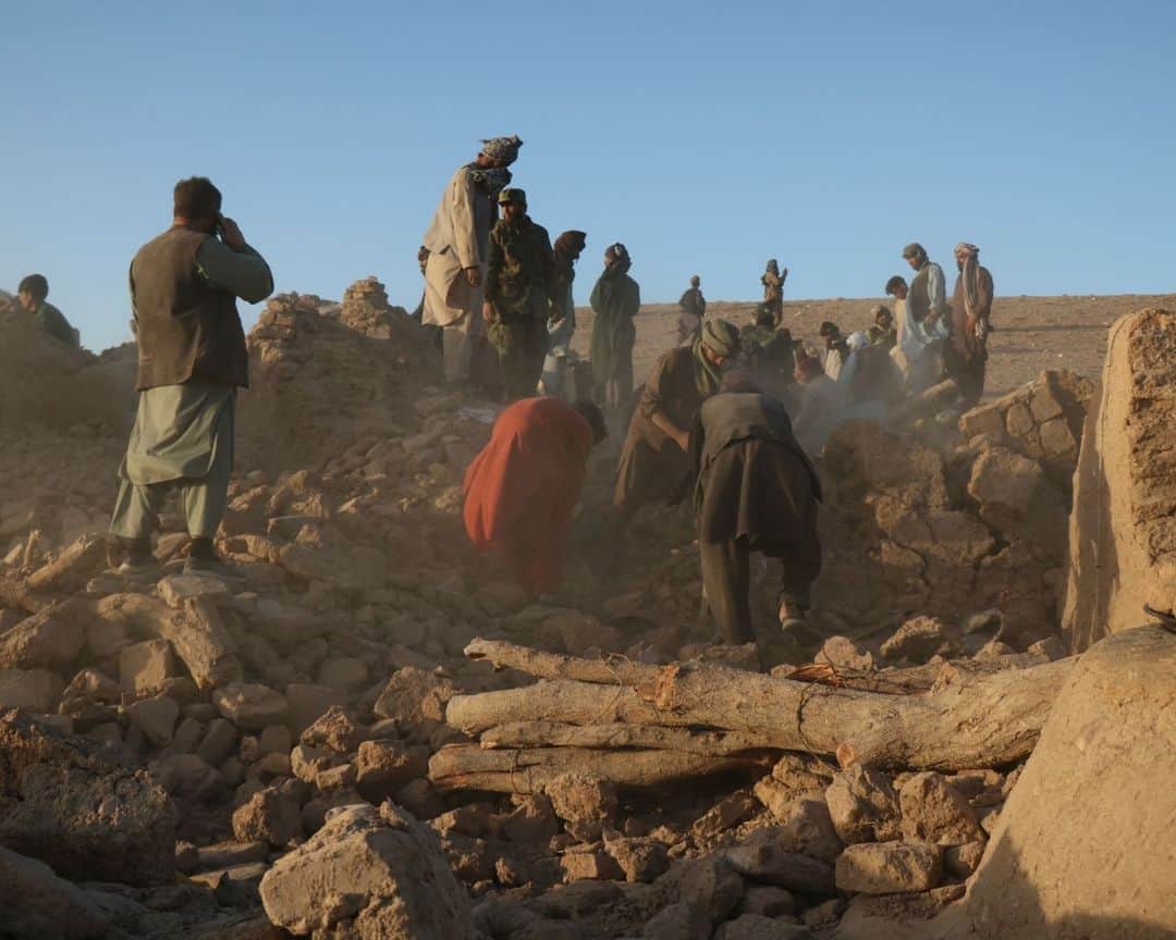 AFP通信のインスタグラム：「Afghan rescuers still digging as hope fades for quake villagers⁣ ⁣ Rescue workers scrabbled through rubble  for villagers buried in their homes by a series of earthquakes that killed more than 2,000 people in rural western Afghanistan, but hope of finding survivors was fading fast.⁣ Volunteers have worked non-stop with spades and pickaxes in Herat province since Saturday's deadly magnitude 6.3 quake struck -- followed by a series of powerful aftershocks -- but some were turning to digging graves instead.⁣ Afghanistan is frequently hit by deadly earthquakes, but the weekend disaster is the worst to strike the impoverished country in more than 25 years.⁣ ⁣ 1 -> 6 - Afghan residents and volunteers clear debris as they look for victims' bodies in the rubble of damaged houses after the earthquakes in Zendeh Jan district of Herat province.⁣ ⁣ 7 - An Afghan man stands near a damaged house after the earthquakes in Sarbuland village, Zendeh Jan district of Herat province.⁣ ⁣ 8 - Afghan residents sit at a damaged house after earthquake in Sarbuland village of Zendeh Jan, district of Herat province.⁣ ⁣ 9 - Afghan mourners sit beside their relatives' bodies from the earthquakes in Sarbuland village, Zendeh Jan district of Herat province.⁣ ⁣ 10 - Afghan mourners offer mass funeral prayers for the people killed in a series of earthquakes in Zendeh Jan district of Herat province.⁣ ⁣ 📷 Mohsen KARIMI #AFP」