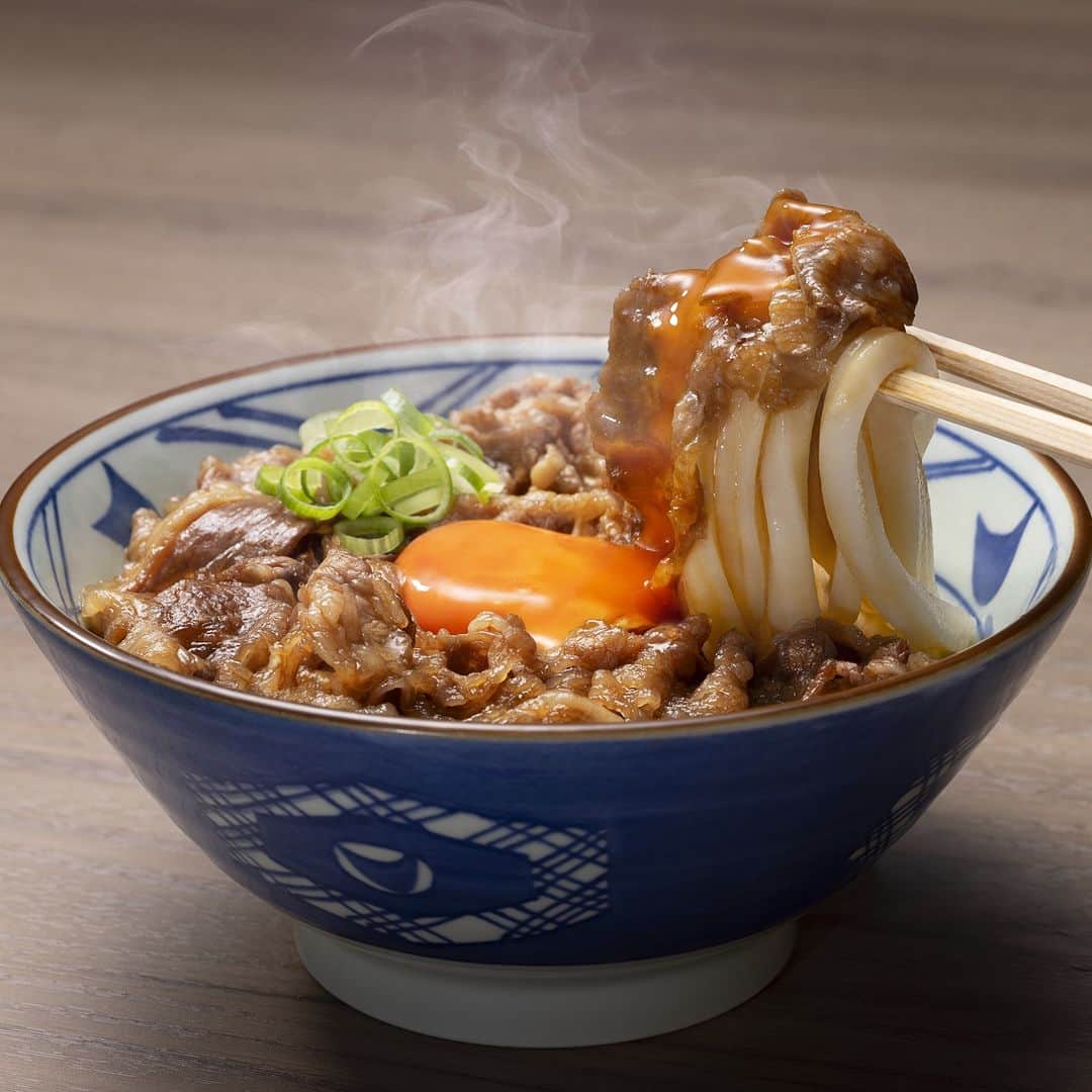 丸亀製麺のインスタグラム：「発売が楽しみ！と思ったら「🔥」で教えてください！  10月17日より #焼きたて牛すき釜玉うどん と #うま辛まぜ釜玉うどん を発売開始します🎉  🐄焼きたて牛すき釜玉うどん お客さまから定番メニュー化の声もいただく人気メニューが約1年半ぶりの復活！注文をいただいてから仕立てるあつあつの牛肉と、とろとろな玉子、もちもちの釜抜き麺が三位一体となって、おいしさが口いっぱいに広がります。  🔥うま辛まぜ釜玉うどん（ひと口ごはんつき） 店舗限定販売だった人気商品が遂に初・全国販売！打ち立てうどんに、店内仕込みの肉そぼろ、ピリ辛白ねぎ、小松菜ナムル、刻みのり、辛かつお粉、こだわりの玉子の6種の具材をトッピング！混ぜるほどにうまいやみつきな味わいです！  販売は10月17日から12月上旬ごろまで！楽しみにお待ちくださいね！  ※一部店舗では販売しておりません。 ※店舗により、お取り扱い商品が異なる場合がございます。 ※焼きたて牛すき釜玉うどんはロードサイドを中心とした店舗にて販売いたします。  #丸亀製麺 #丸亀うどん #udon #麺 #うどん」