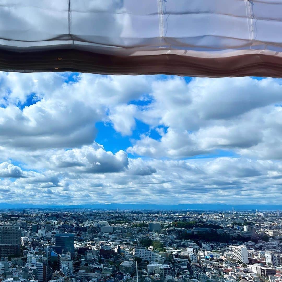 辛島美登里のインスタグラム：「そして今日は空模様がよく変化した一日でした。  クロワッサン🥐が並んだ青空のオーブン→天使の梯子が降りてきて👼 線状降水帯の雨で視界がグレー→後に穏やかな夕陽に染まるオレンジ  という窓シアターでした🎞️ 年末に近づくにつれ 夕景が美しくなるスタジオキャロットタワーです🥕 The changing sky, blue →gray →orange」