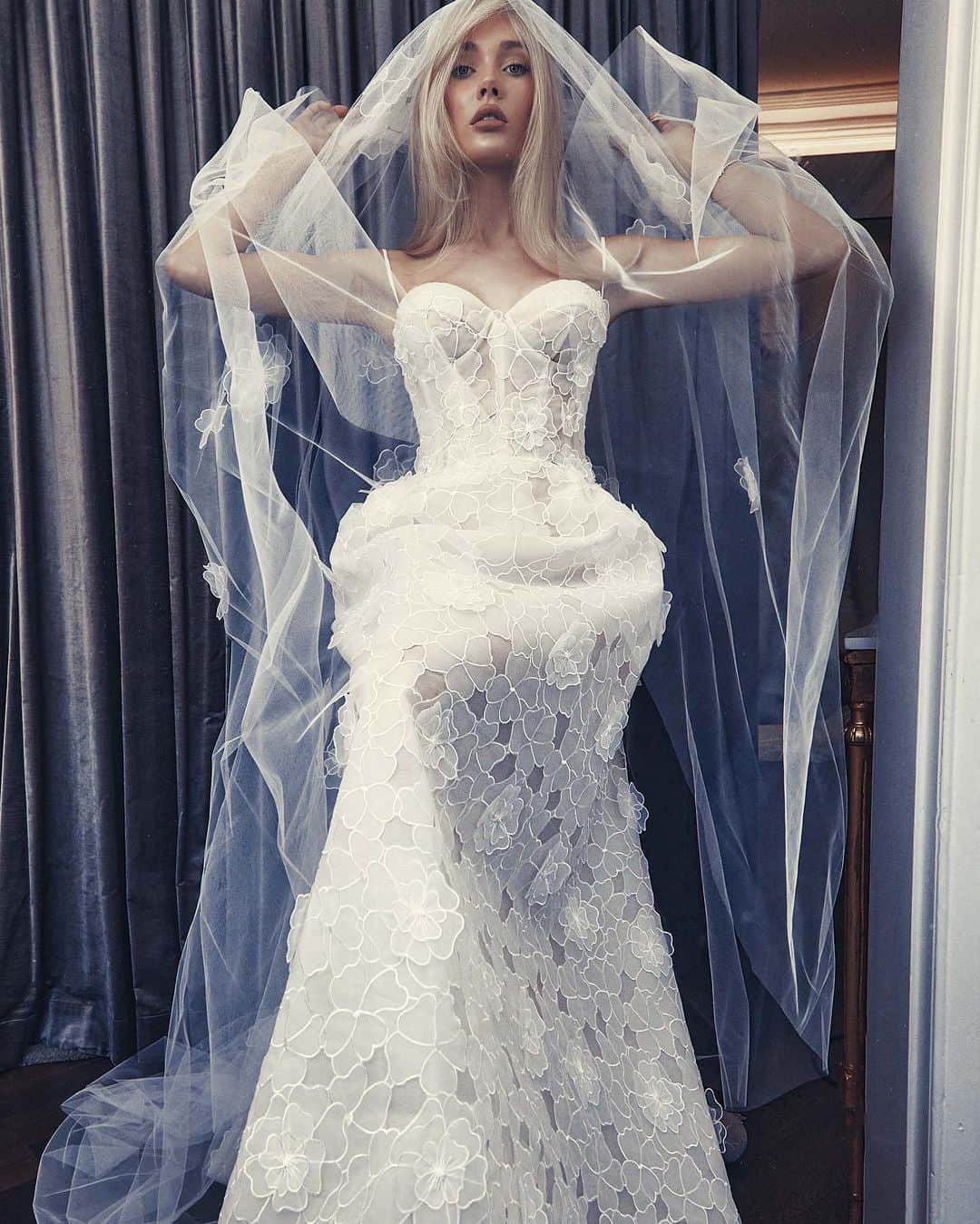 のインスタグラム：「Introducing the Fleur gown, a breathtaking embodiment of timeless elegance and delicate charm. Adorning the pale latte tulle are exquisite silk white florals, meticulously crafted to create an enchanting garden of blooms ​​​​​​​​​​​​​​​​​​Available via our Paddington Atelier or worldwide stockists.   #stevenkhalil #stevenkhalilbride #weddinggown #bridal」