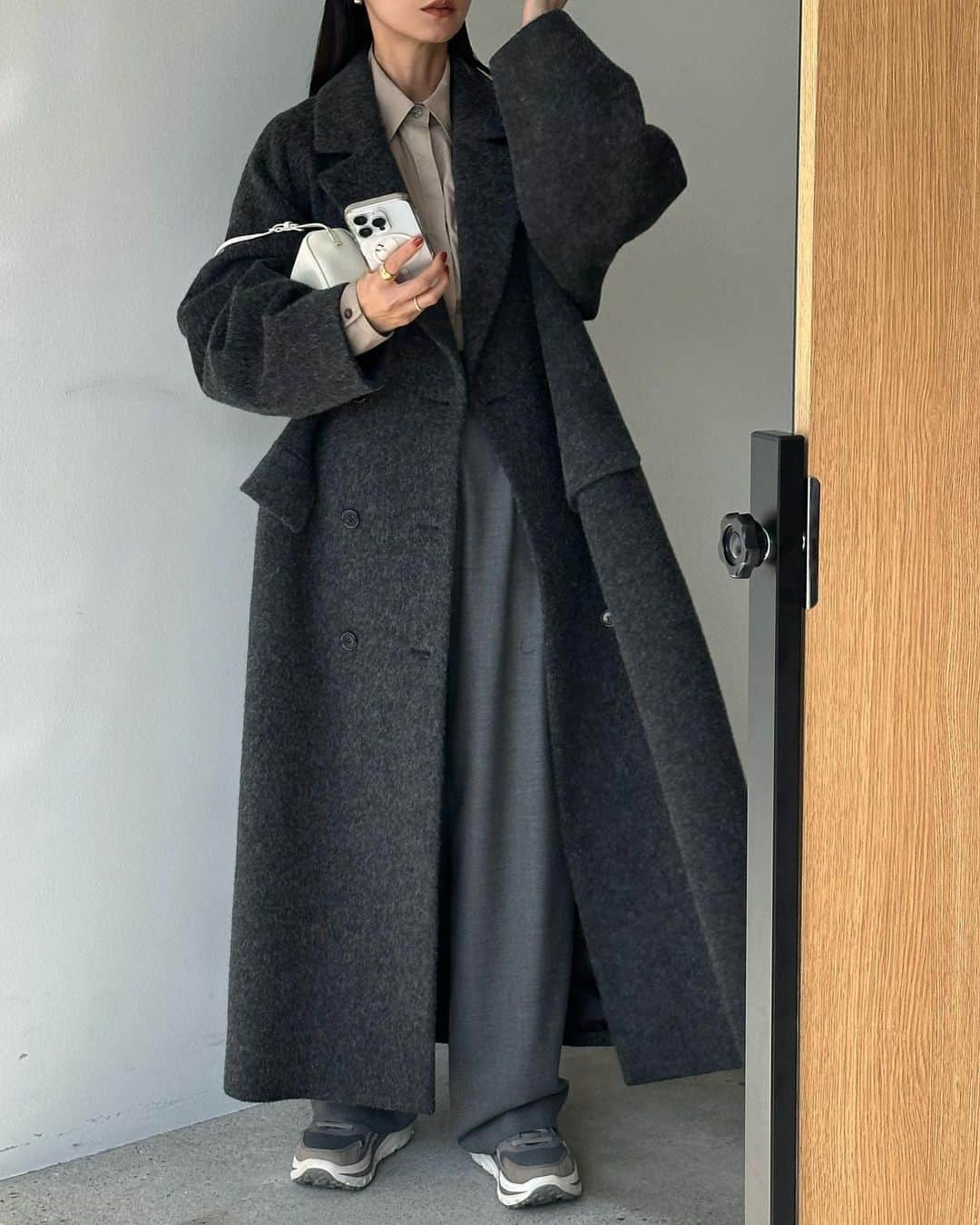 松本恵奈のインスタグラム：「こんばんは。明日からスタートする福岡POP UPにCLANE定番アイテムのDOUBLE WOOL LONG COATが先行入荷されます◯  毎年好評のシャギー素材を使ったCLANE定番のダ ブルウールロングコート。オーバーサイズと長めの丈感でモードな印象に着て頂けます。オリジナルの シャギー素材は、昨シーズンより毛並みを上品に仕上げ、より重厚感を出してアップデートしています。コーディネートしやすい人気のブラウンは、今季の気分を少しだけ足したNEWカラーに。絶妙な色差 の糸をミックスさせた杢調のグレーカラーと、柔らかなモスグリーンを新色で追加しました。幅広いスタイリングに合わせやすく着回し力も抜群な人気アウターです♡ 私も初期のBEGを持っているのですが飽きないので毎年、大切に着ているコートです☺️ 是非お楽しみにっ！ #clane #福岡 #popup #先行入荷」