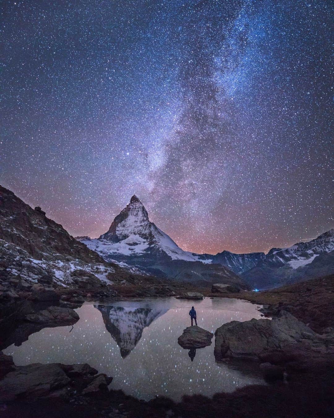 National Geographic Travelさんのインスタグラム写真 - (National Geographic TravelInstagram)「Photo by @chrisburkard | I've found landscapes inspiring but also our interaction with them beautiful and worthy of documentation. On a cold night in 2015, Stellisee, a lake in Zermatt, Switzerland, seemed like the perfect place to capture the Milky Way juxtaposed with a single viewer. A notable lack of wind allowed for a reflection to emerge, providing the moment I was looking for—and one I hoped others would imagine themselves in when seeing the photo. #WorldSpaceWeek」10月11日 1時30分 - natgeotravel
