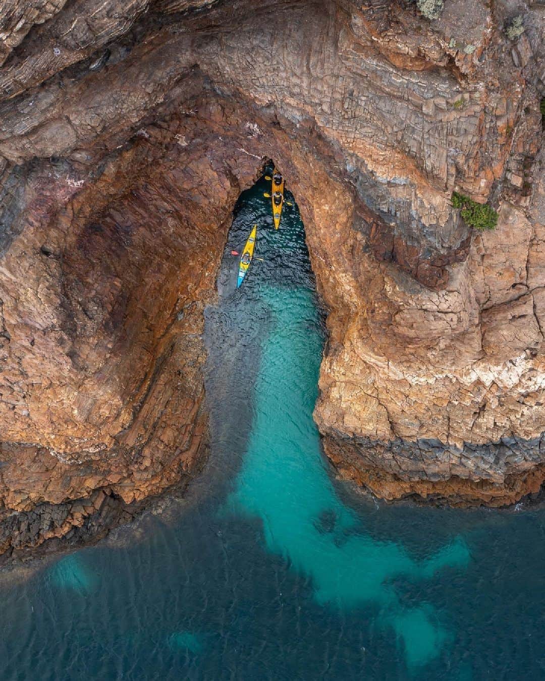 Australiaのインスタグラム：「Oh, @officialfleurieupeninsula 🥹🩵 If @__serio__'s stunning shot of #RapidBay doesn't have you packing your bags and heading straight to this paradise in @southaustralia, we don't know what will! Nestled amongst rolling green hills and sandy white beaches, you'll find this gem just over an hour from Tarntanya (@cityofadelaide), making it the perfect spot for a cheeky day trip! Take in the spectacular views from the shore, or paddle out with water @adventurekayakingsa to discover the hidden beaches and sea caves dotted along the coastline 🛶.   #SeeAustralia #ComeAndSayGday #SeeSouthAustralia #FleurieuPeninsula  ID: Two kayaks glide over clear turquoise waters, approaching the entrance of a rugged coastal cave.」