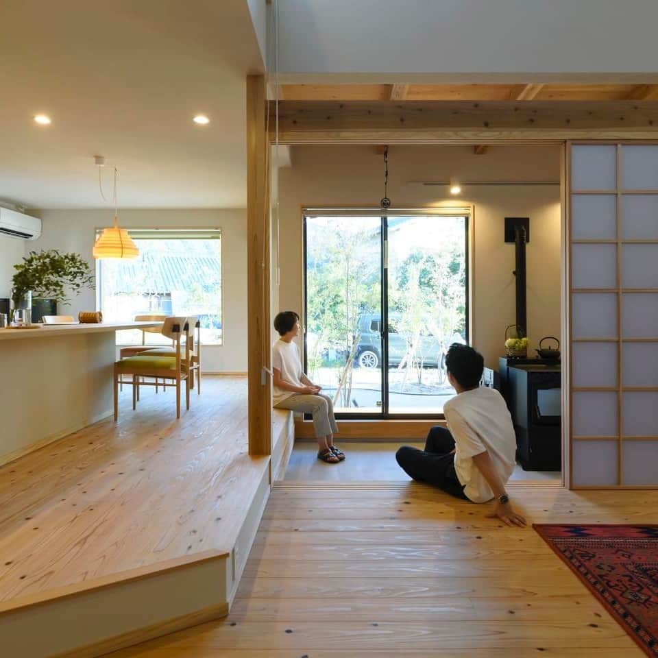 家づくりの本ふくおか・さがさんのインスタグラム写真 - (家づくりの本ふくおか・さがInstagram)「.  大人の暮らしを楽しむ スローライフの家 －－－－－－－－－－ 長崎材木店 @nagasaki_architect －－－－－－－－－－  テーマは大人が楽しめる和モダン。和の設えと遊び心がそこここに施され、心地よさとゆとりを感じる贅沢なしつらえ。  “里山”をイメージし、家を囲むように植栽をした外構。ブラウンベージュの外壁が、天然木と緑にしっくりと馴染む。 一見平屋のようだが、2階にロフト空間のある1.5階建て。何といっても特徴的なのは、玄関を開けると広がる広い土間スペース。リビングをぐるりと囲むようにL字型に設けられた土間には、ペレットストーブやご夫妻の趣味である釣り竿置きを設置。大きな吹き抜けの開放的なLDKは、ダイニングキッチンを床から一段高くして空間に変化を加え、カウンターとダイニングテーブルを一体化したオープンキッチンは、さながら和食料理屋のよう。  もちろん、見た目だけの良さでなく機能性＆実用性もバッチリ。床は足触りが心地よい、杉の“うづくり”を採用。収納スペースを十分に確保し、生活感が出る家電も収納。スッキリ見えを叶えた。  －－－－－－－－－－－－－－－－－－－－ 詳しくは現在販売中の 【家づくりの本 ふくおか・さが 2023夏号 No.60】でご覧ください。 　 【ご購入はこちらから】 https://fukunavi.stores.jp/items/64a245946cb14b002b73ceb2 －－－－－－－－－－－－－－－－－－－－ 　 ■長崎材木店 福岡東スタジオ [所] 福岡県古賀市天神5-10-3 [☏]　092-942-2754 //////////////////////// 　 【家づくりの本】 → @iedukuri.fukuoka  　 【フクオカリノベ】 → @fukuoka_renovation  　 　 #家づくりの本 #シティ情報ふくおか  #マイホーム #暮らしを楽しむ  #新築 #戸建て #注文住宅  #家づくり  #福岡 #福岡新築 #福岡家づくり  #家づくりのヒント #暮らしのヒント  #かっこいい家 #お洒落な家 #自然素材の家  #インテリア #インテリアデザイン  #住まい #暮らし #家 #住まいづくり  #工務店　#施工事例 #長崎材木店 #長崎材木店一級建築士事務所」10月11日 13時26分 - iedukuri.fukuoka