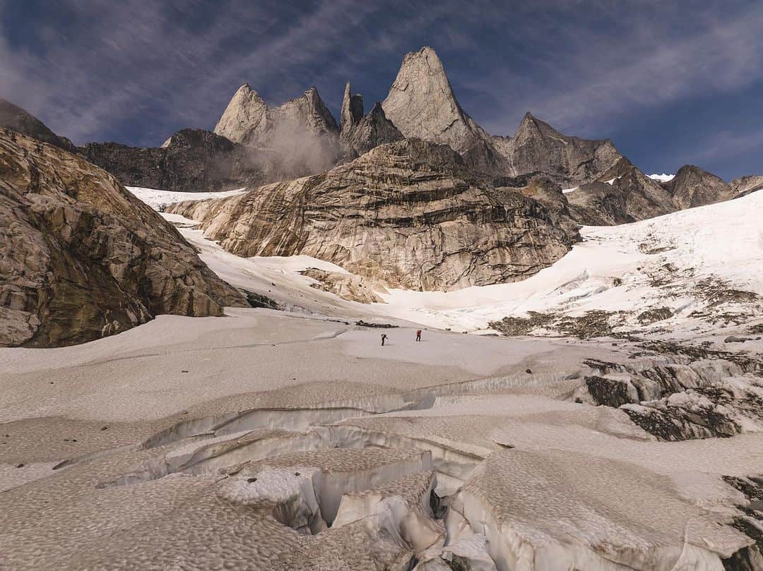 アレックス・オノルドさんのインスタグラム写真 - (アレックス・オノルドInstagram)「This shows the approach up to the Devils Thumb, and our camp situation. First pic is a @renan_ozturk drone pic of @tommycaldwell and me hiking up the ice falls below the Thumb. The second is my scrappy iPhone pic of our tents at sunset (there’s a reason I’m not the pro…).  It was interesting visiting the Thumb - it’s way, way more melted out than anything we’d seen in pictures. Part of that is because we were there in late season, but part of it is that the glaciers have receded an incredible amount. As an example, the previous party who did the DT traverse recounted a simple, 45min snow romp from camp over to the start of the climbing. We did 2 hours of navigating rock fins and ridges that have all emerged as the ice has retreated in the last 10+ years.  This is part of the reason that any real climber is at least some kind of environmental advocate - it’s so easy to visually see how quickly the world is changing in the big mountains. It’s a bit sobering.」10月12日 5時19分 - alexhonnold