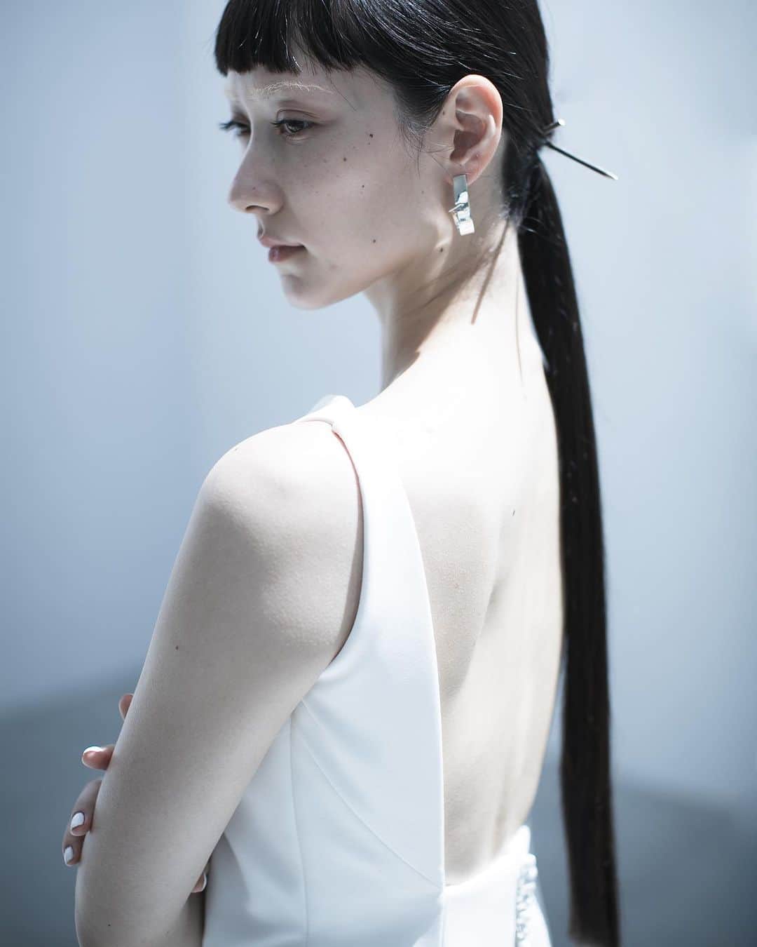 nae.ATELIERのインスタグラム：「nae.ATELIER 2023 new dress 【"isana"(イサーナ)】  派手ではないけれど、 モードでスタイリッシュなものがお好きな方へ向けてお作りしたマーメイドラインドレス。  鎖骨と肩の骨格を美しく印象的に見せるよう 直線的でスタイリッシュなネックラインとアームホールのラインに。  露出が少なくおさえ気味なフロントスタイルに対して、大胆に開いたバックスタイルが内に秘めた意志の強さを表現します。  体に心地よくフィットするストレッチ生地の上に、 柔らかく光を通す美しいシルクオーガンジーを重ねたトレーンが 立ち姿のしなやかな曲線美を印象付けるソフトマーメイドラインドレスです。  earrings @horn_tokyo   “Isana” is soft-mermaid line dress made of stretch fabric that comfortably fits the body, and beautiful silk organza for a train that allows soft light to pass through.  This dress is for brides that love modernity.  nae.ATELIER 東京都渋谷区恵比寿南1-13-2 EBISU COURT 101 TEL:03-6409-6369  #大好きと大切をすべてまとって #naeatelier #アトリエナエ #nae花嫁 #bridestyle #overseaswedding  #destinationwedding #elopementwedding #naebride #ウェディングドレス #シンプルドレス #isana」