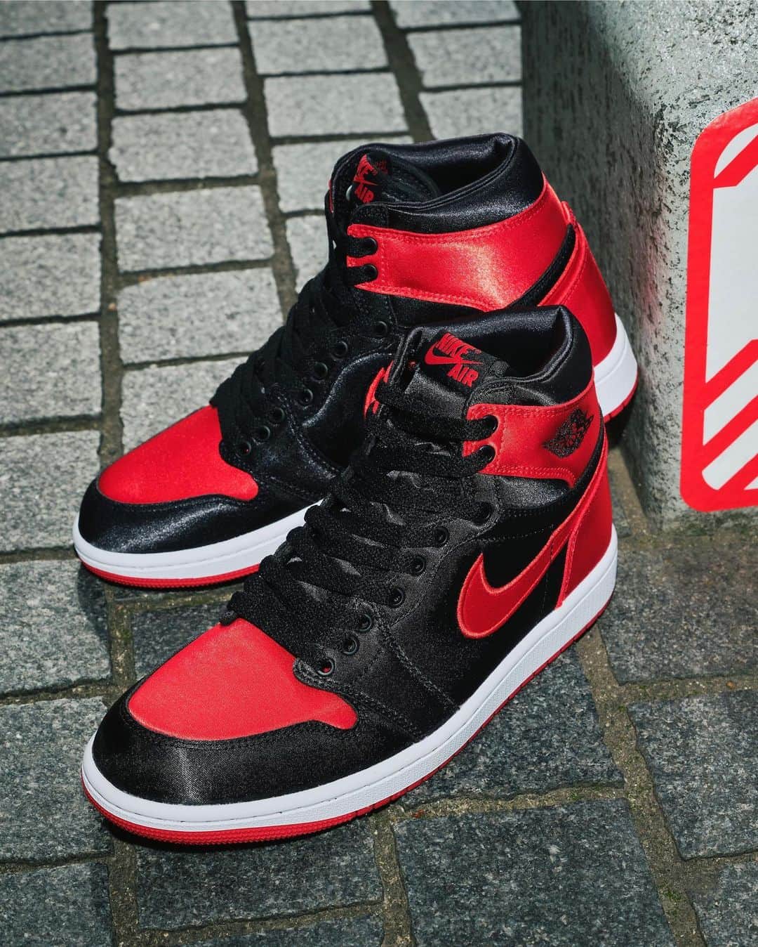 アトモスのインスタグラム：「. WMNS AIR JORDAN 1 HIGH OG "Satin Bred"	  AIR JORDAN 1を履いたら、スポットライトが当たっていると思って欲しい。1985年のオリジナルとブラックとレッドのカラーをベースに光沢のあるサテンを使い、そんな光を跳ね返す一足が登場する。 2016年に発売された501足限定の"Satin Bred"の復刻にあたる本作は、2ndシューレースで雰囲気を変えたり、ダブル使いのスタイルを楽しんだりもできる。ギアを入れて持ち運べるJumpmanバッグも付属している。 本商品は現在atmos-tokyo com にて抽選受付中 。 10月18日(水)より atmos 各店 一部店舗除く 、 atmos オンラインにて発売致します。  WMNS AIR JORDAN 1 HIGH OG "Satin Bred"	  When you wear the AIR JORDAN 1, you want to think you're in the spotlight, and with a glossy satin base in the black and red colors of the 1985 original, here comes a pair that bounces back in that light. This reissue of the "Satin Bred," which was limited to 501 pairs in 2016, also features a 2nd lacing for a different vibe or a double-use style. A Jumpman bag for carrying gear is also included. The product is currently being raffled off at atmos-tokyo.com. The shoes will be available at atmos stores and online from October 18 (Wed.).  #atmos #airjordan1 #aj1」
