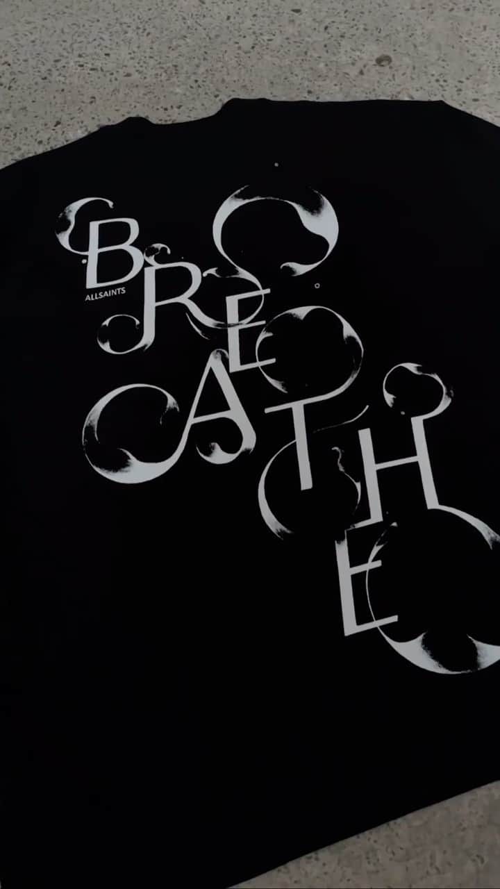 オールセインツのインスタグラム：「Designed by our Creative Visual Merchandiser @myles_myles, this is the Moments T-Shirt. The typographic illustration is inspired by taking a moment to be mindful and breathe with the movement in the text being expressive of the feeling of inhaling and exhaling.   All profits will be donated to the UK charity Black Minds Matter and the US charity Black Girls Smile. @blackmindsmatter.uk helps to support Black mental health services and provides access to Black therapists. @blackgirlssmile provides gender-responsive and culturally-affirming mental wellness education, resources and support geared toward Black women and girls.」