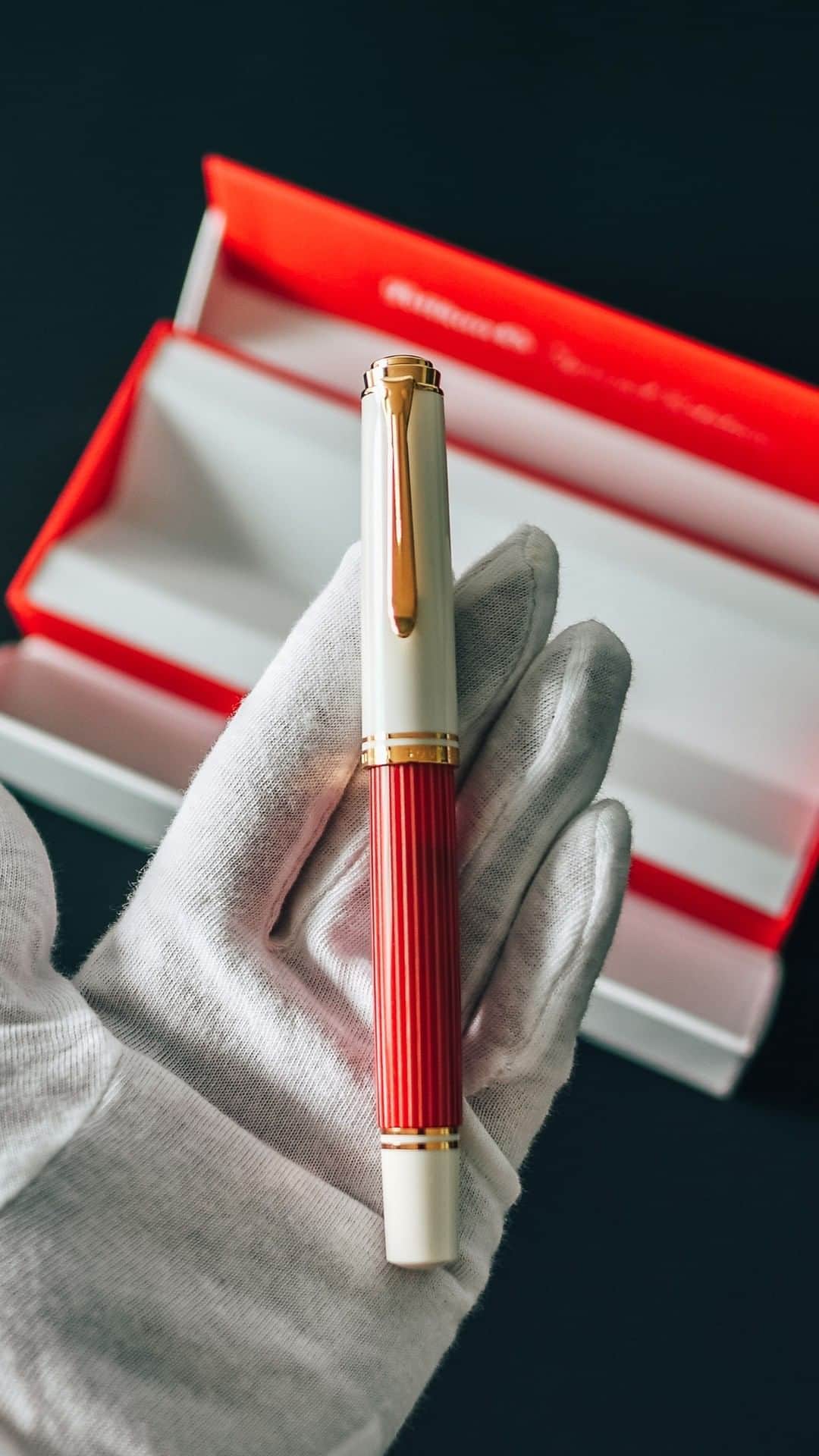 ペリカンのインスタグラム：「Unbox pure elegance! ✨ Our latest creation, crafted from high-quality resin, shines with an irresistible luster. The meticulously fashioned red and white striped barrel combines durability and beauty. With 24-carat gold-plated rings and the iconic Pelikan clip, it's a touch of opulence you won't want to miss. Choose between the fountain pen, featuring a 14-carat bi-color gold nib, or the practical twist-mechanism ballpoint pen for effortless elegance. Which one will you choose?  #PelikanPassion #PelikanSouverän #PelikanSouveränRedWhite」
