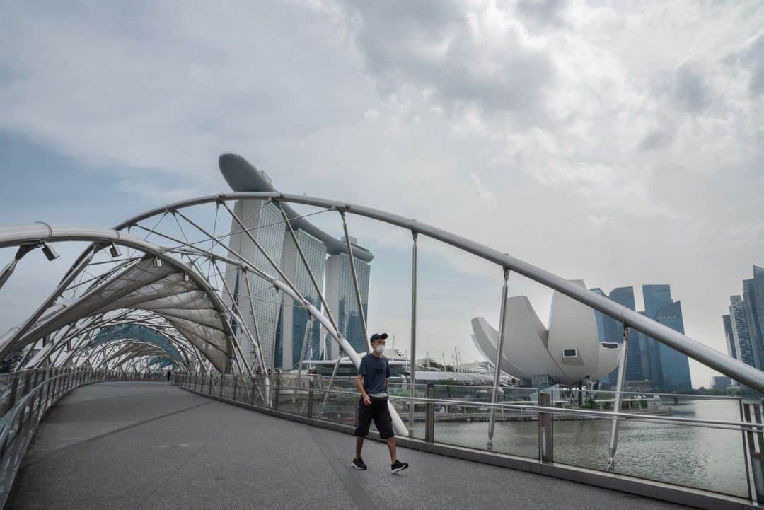 National Geographic Travelのインスタグラム：「Photo by @amritachandradas | A man crosses Singapore’s Helix Bridge. This spot is popular with photographers and tourists who want to capture Singapore’s skyline at sunset.   Please follow me @amritachandradas for more insight into my work and travels.」