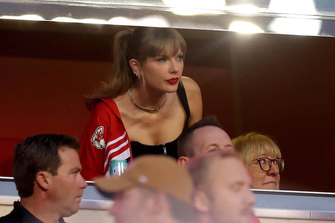 ELLE Magazineのインスタグラム：「#TaylorSwift is back in the stands, cheering on #TravisKelce with his mom #DonnaKelce. The first photos have come out of Swift at the Kansas City Chiefs game against the Denver Broncos. The singer was dressed impeccably in a chic black corset top and a Chiefs jacket. Link in bio for more details and photos from Swift's latest show of support for Kelce.❤️」
