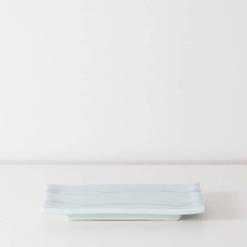 有限会社マルヒロさんのインスタグラム写真 - (有限会社マルヒロInstagram)「【マルヒロおすすめの長皿】  ⚪️藤巻製陶 青白磁 遠山 付出  有田の藤巻製陶さんの長角皿です。約250年の歴史を持つ藤巻製陶さんは、美しい青白磁で知られる窯元です。BARBAR 青白磁シリーズも藤巻製陶さんに制作を依頼しています。  今回販売する藤巻製陶さんの長皿は30～40年前に作られたデッドストックのお皿です。鮎皿や付出用に業務用に生産されていたものだそうです。  「青白磁 遠山 付出」は、遠くに見える山や木が描かれており、その素朴なタッチが心を和ませてくれます。淡く柔らかい水色はお料理を引き立ててくれるでしょう。  卵焼きやおにぎりプレート、お刺身にちょうどよさそうです。  ----------------------- オンラインストアにて詳細ご覧いただけます！ @maruhiro.hasami のURLリンクからどうぞ！  https://store.hasamiyaki.jp/html/page328.html  #マルヒロ #まるひろ #maruhiro #HASAMI #BARBAR #波佐見焼 #陶器 #磁器 #通販 #食器 #器 #ceramics #pottery #長皿」10月13日 11時55分 - maruhiro.hasami
