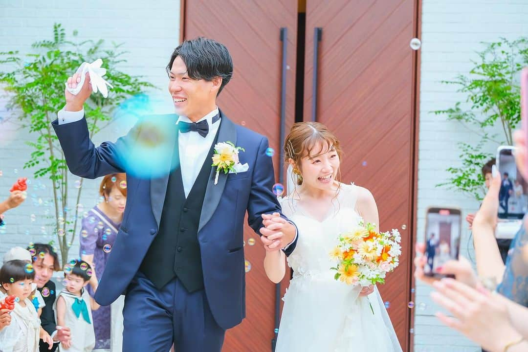 ザ・ピーク プレミアムテラスのインスタグラム：「. 祝福のシャボン玉🫧シャワーの中のご入場  @fiorebianca_wedding @cocon.by.chloriscinq   ............................................................ 【2022年口コミ7年連続受賞】  \ゲスト満足度❤︎鹿児島県No.1/  ▪︎天空からまばゆい光が降り注ぐ 純白のチャペル ▪︎鹿児島中央駅・天文館から近い 鹿児島唯一の好立地 ▪︎完全貸切の空間で 特別感に包まれた心地よい1日を .......................................................... スタッフブログやㅗ 卒花レポート 会場見学 こちらからご覧いただけます♩  ▶︎ @thepeak_wedding トップページURLの 公式HPより、、、❤︎  #ファーストミート #ファーストミートサプライズ #鹿児島#鹿児島花嫁 #ザピークプレミアムテラス #2023春婚 #2023夏婚 #2023冬婚 #wedding#ウェディング#家族婚ウェディング #親族婚 #親族結婚式 #少人数婚 #ウエディングブーケ #ナチュラルウエディング #大人ウエディング #花嫁さんの力になりたい #ウエディングフォト #おしゃれウエディング #カメラ #天文館 #コロナ対策 #ドレス迷子 #ブライダルヘア #結婚式アイディア #鹿児島結婚式#鹿児島結婚式場#鹿児島結婚」