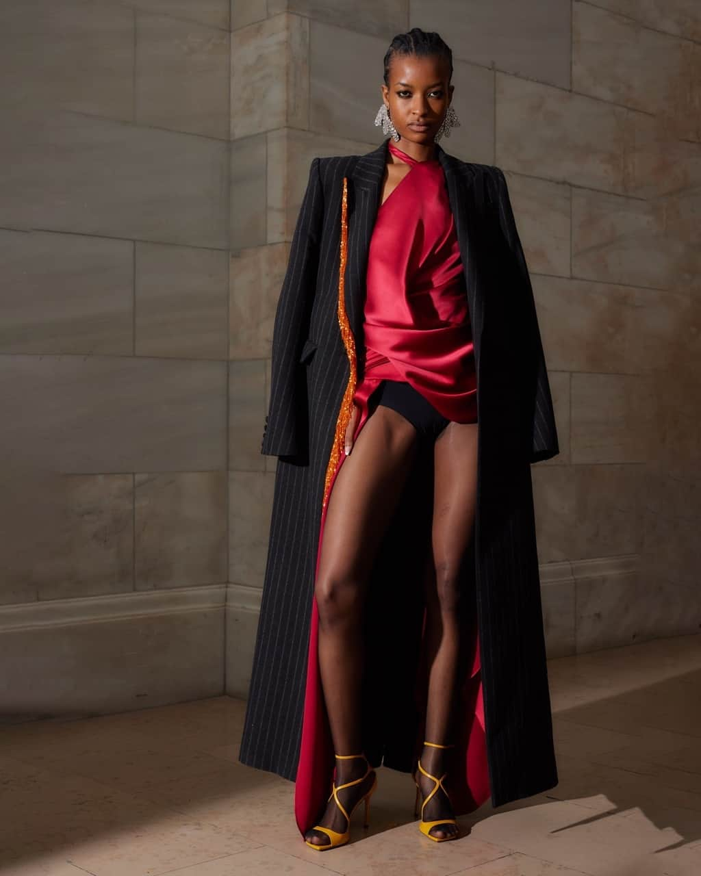 プラバルグルンのインスタグラム：「Pretty Pinstripe⁠ ⁠ Black Pinstripe Wool Peak Lapel Duster Coat with Orange Bugle Fringe with Scarlet Satin Draped One Sleeve Blouse from the Fall Winter 2023 collection⁠ ⁠ Photo by @eganadrew」