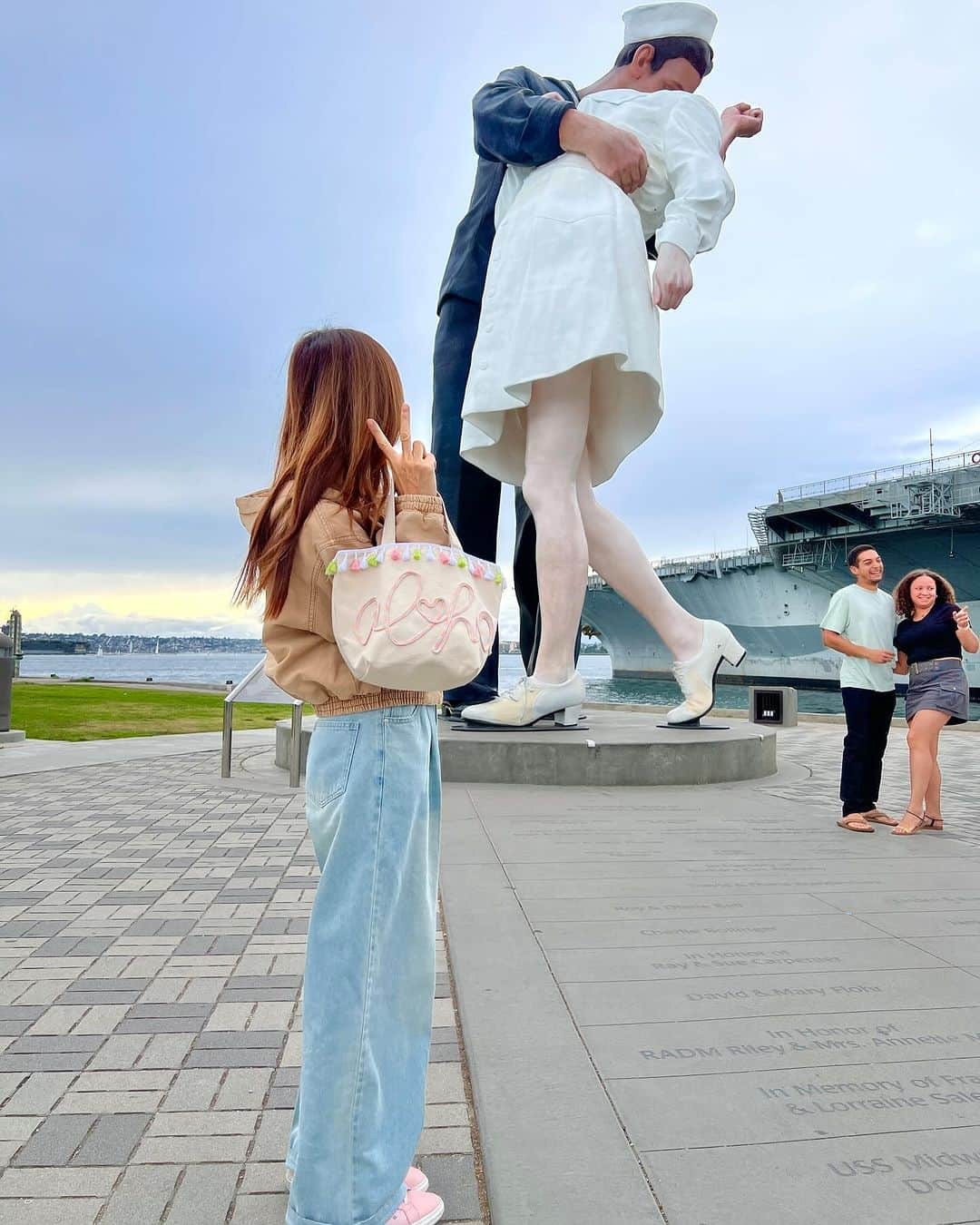 Moco Lima Hawaiiのインスタグラム：「ナースにキスする水平さん【勝利のキス】with Aloha tote  何年か前、初めてこの像を見た時  戦争に行った彼の帰りを待ち侘びていたナースが彼と再会。 勝利と再会を喜び合うキスでステキだな、と思っていましたが  実は2人は赤の他人で  戦争で長い間、女性に触れていなかった兵士が勝利と生還で喜びの余り、たまたま隣に居合わせたナースに  “勝手にキスしちゃった写真”   だと知り、それ以降少し見方が変わってしまいました😅  そういえば水平さんの左腕、がっちりホールドしてるよね😓  #サンディエゴ#勝利のキス#水平さん#ナース#戦争#彫刻#観光スポット#サンディエゴ旅行#カリフォルニア#サンディエゴ観光#いつも一緒#3回目#歴史#戦争#アロハトート#トートバッグ#モコリマハワイ」