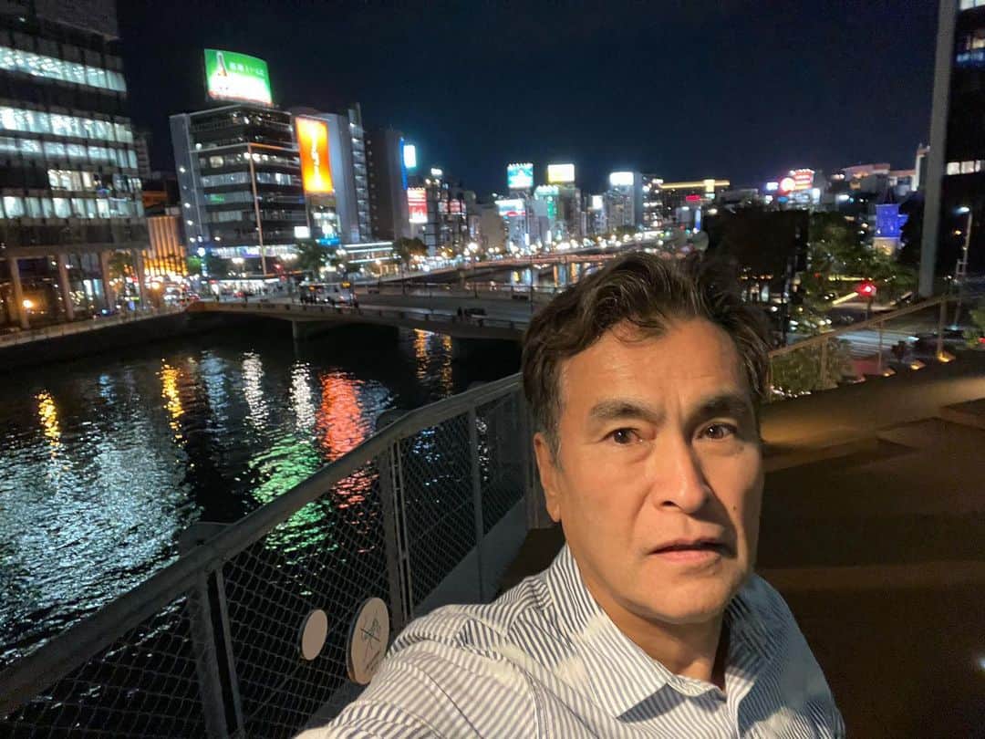 石原良純のインスタグラム：「福岡市中洲を望む水上公園。美味しいものを食べて、美味しくお酒を飲んだら、ぶらり立ち寄るお気に入りの場所。 真夏でも公園の小高いデッキに登れば、那珂川を上ってくる潮風が心地よい。夜風が冷たくなった今ならば、酔って熱った顔にはなお心地よい。 さあ、次の店に繰り出すか。いえいえ、朝6時のアサデスの生放送に博多入りしているわけ。とっとと宿に帰って寝ました。マジ。」