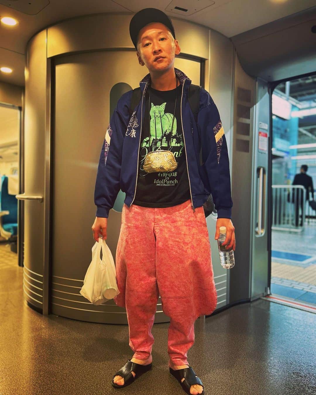 のインスタグラム：「今日の服装。 大阪でライブの日。  石野卓球とidol Punchの猫のロンTに健康のジャージ。 ピンクのニッカ。 十四才で購入した帽子に黒の便所サンダルと金のがま口でmont-bellのメッシュリュック。 大阪で元祖！あっぱれコント組でした。 弾丸日帰りで新幹線ギリギリで乗り込んで撮りました。 腹減った。 大阪ありがとう。  #今日着た服 #ファッション #古着 #大阪 #健康」