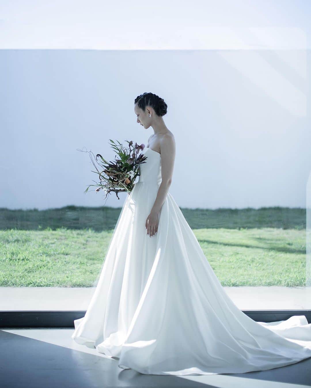 のインスタグラム：「nae.ATELIER 2023 new dress 【”amira”(アミーラ)】  nae. ATELIERのために作られた、 上品な輝きのある光沢と　 コシのあるしなやかな動きが美しい 国産のシルク生地を贅沢にたっぷりと使用した、 王道かつスタイリッシュなAラインドレス。  スカートのウエストに入るダブルタックが、 迫力のある優美なシルエットを作ります。  天井の高い会場や ホテルウエディングにぴったりな一着です。  “amira” is modern A-line dress made of luxurious domestic silk fabric made exclusively for nae. ATELIER.  The double tucks on the waist of the skirt create powerful and elegant silhouette.  This is the perfect outfit for a venue with high ceilings or a hotel wedding.  nae.ATELIER 東京都渋谷区恵比寿南1-13-2 EBISU COURT 101 TEL:03-6409-6369  #大好きと大切をすべてまとって #naeatelier #アトリエナエ #nae花嫁 #bridestyle #overseaswedding  #destinationwedding #elopementwedding #naebride #ウェディングドレス #シンプルドレス #amira」