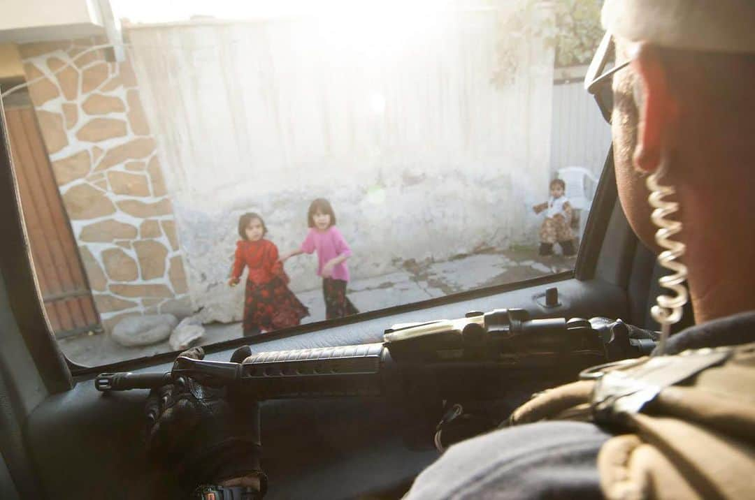 thephotosocietyのインスタグラム：「Photo by @mattmoyerphoto // In this deeply troubled time let's remember the children caught up in war. May their wellbeing be the priority for all who are making life and death decisions. From my Archive: Young Afghan children look on as a private security contractor rides in an SUV while providing security for a convoy in Kabul, Afghanistan.」