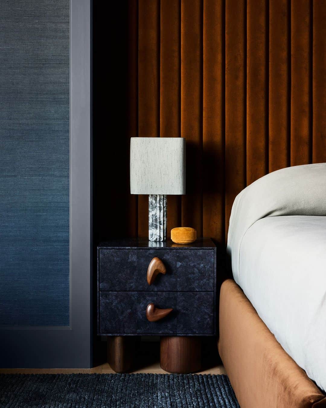 ELLE DECORのインスタグラム：「Looking for an escape? Try using dark colors and cozy textures in your bedroom. This luxurious sleeping space, designed by San Francisco studio Homework (@homeworkdesignshop), has inky blue walls to allow you “to sort of remove yourself from the energy of the rest of the house,” firm cofounder Ben Work explains. The custom bed, in the designers’ words, is “gargantuan” and is backed by a floor-to-ceiling, channel-tufted headboard covered in an “incredible yummy brown mohair by @lamaisonpierrefrey,” adds firm cofounder Susan Work. “We wanted to bring in the ultimate cozy factor here.”  Click the link in bio to discover the rest of this sophisticated family residences. Written by @anna_fixsen. Photographed by @nicole_franzen.」