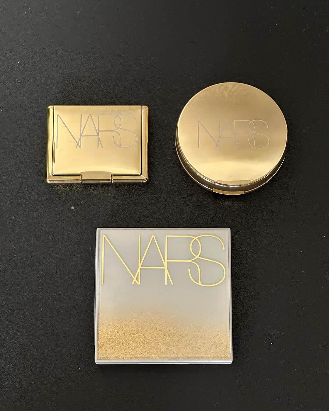 のインスタグラム：「★NARS★  左側 ⚫︎フェイタルアトラクション　ブラッシュ  アイコニックなソフトピーチカラーのブラッシュが、ホリデー限定のメタリックゴールドパッケージ  真ん中 ⚫︎エンドレスナイツ アイシャドーパレット  きらめきと輝きを放つホリデーコレクションからアイシャドーパレットが誕生しました。ゴールドのグリッターで装飾されたホリデー仕様のパッケージを開けると現れるのは、多彩な9つのシェード。シマーなニュートラルカラーからポップなピンク、パープルなどの光彩が、奥行きのある華やかな目元を演出  右側 ⚫︎ゴールデンスパーク　ピュアラディアントプロテクション　アクアティックグロー　クッションファンデーション　  ピュアラディアントプロテクション　アクアティックグロー　クッションファンデーション専用ケースに、ホリデー限定のメタリックゴールドコンパクトが登場。どこへ行くにも、ラグジュアリーを持ち歩いて。  #narscosmetics」